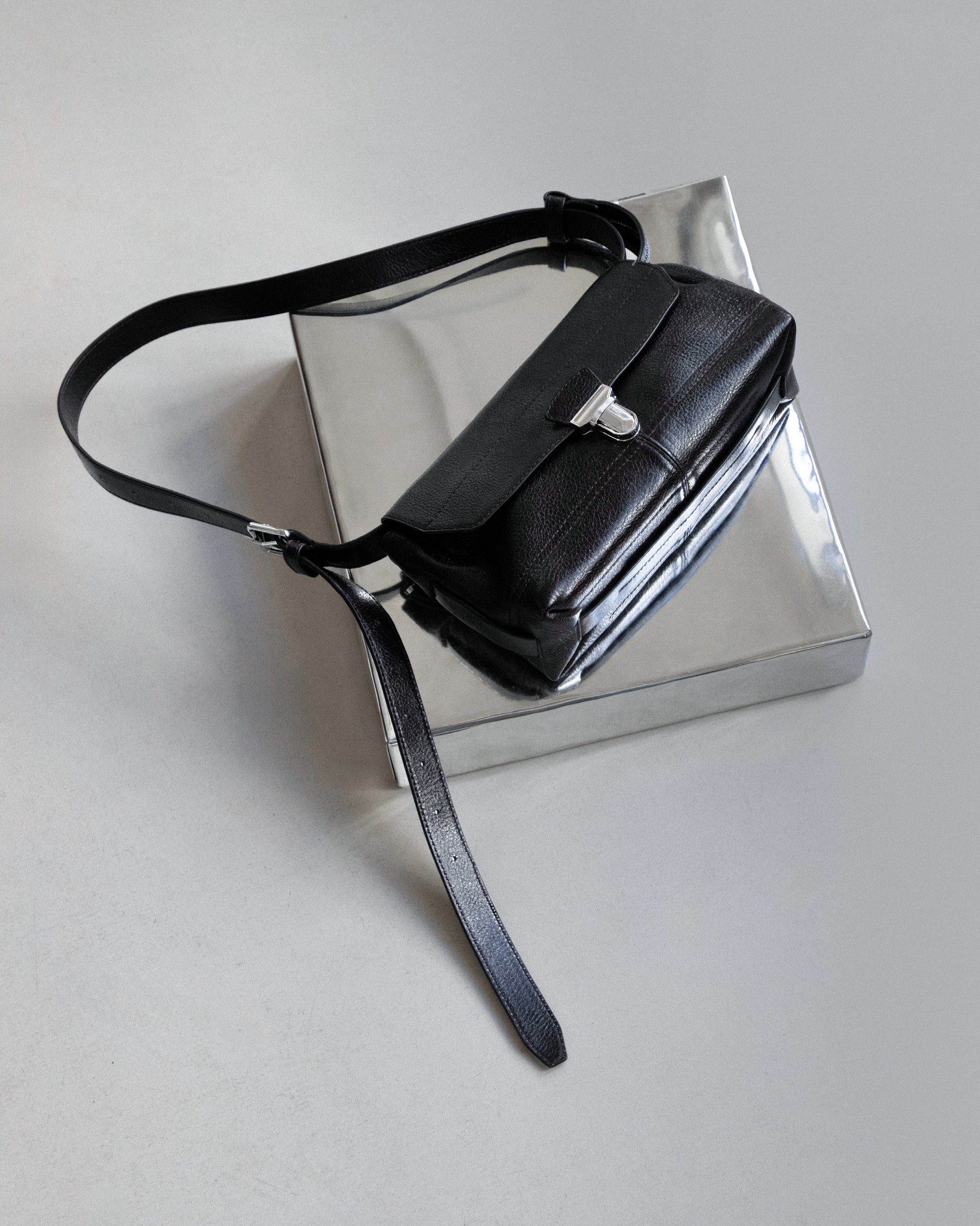 Leather shoulder bag in Black leather, product shot, Angled top view Minimal design