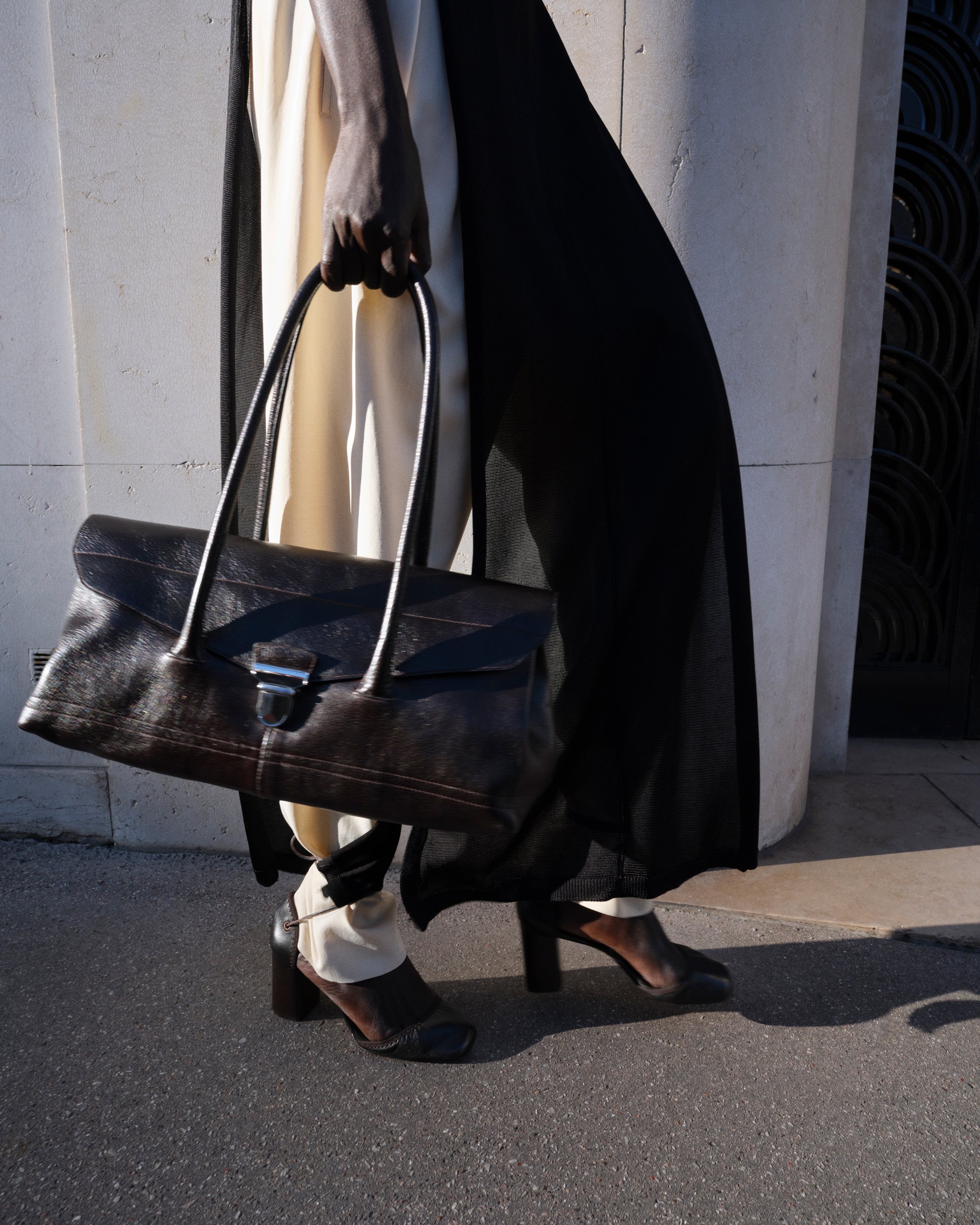 Leather handbag in Black leather, model shot, Side view Minimal design