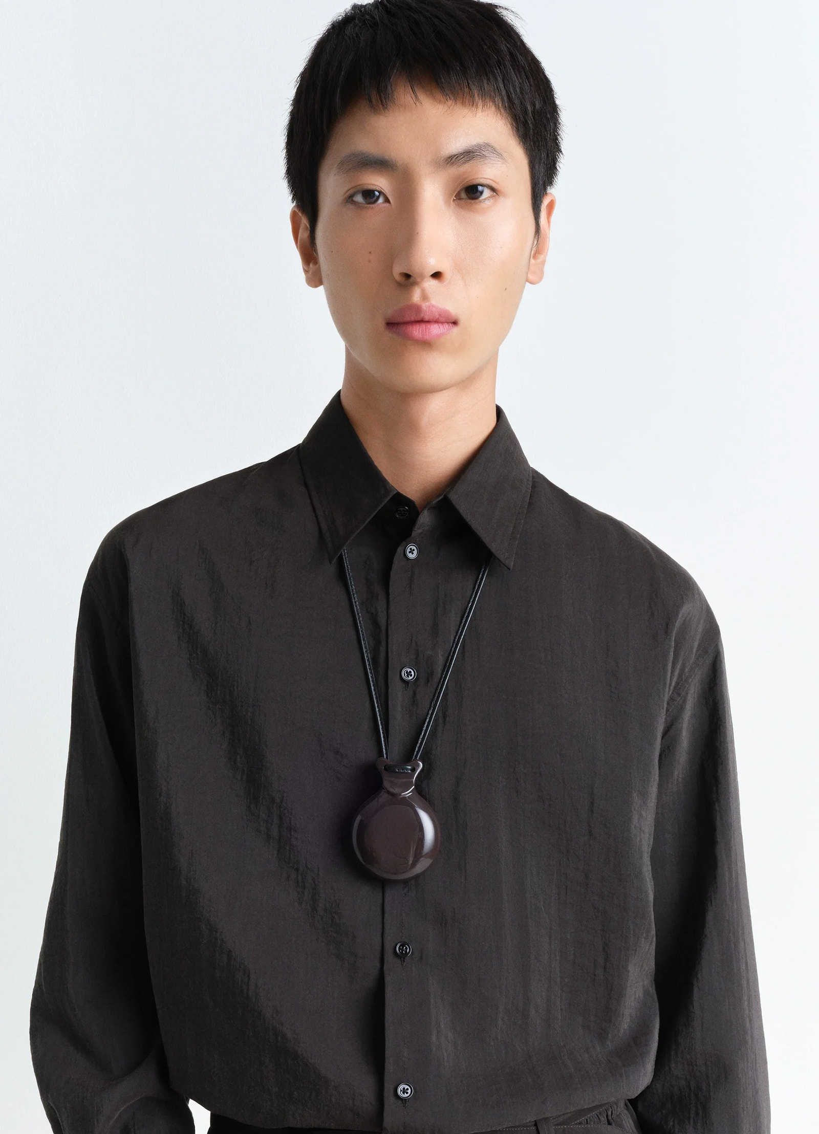Lemaire castanet necklace in dark brown resin, model shot, worn close-up sleek minimalist