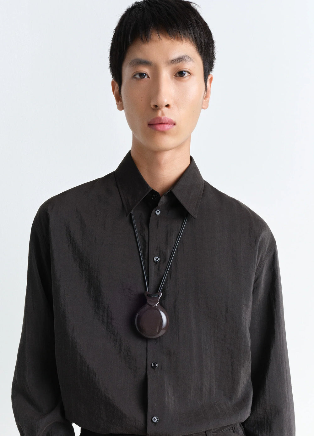 Lemaire Castanet Necklace in Dark Brown Resin, model shot, worn close-up sleek minimalist