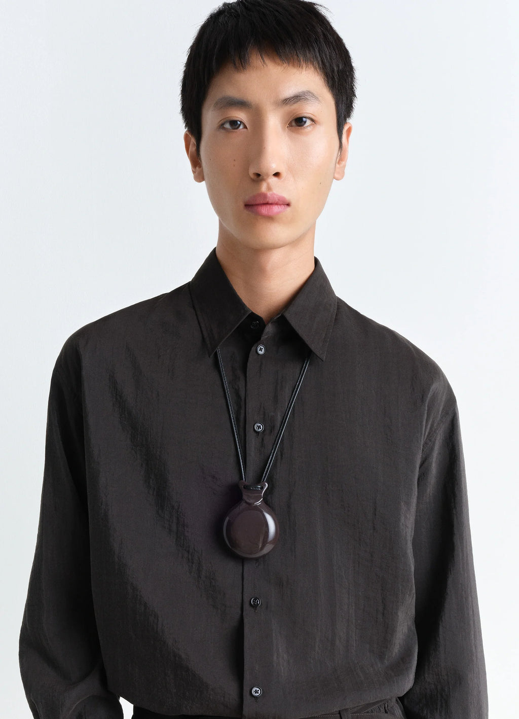 Lemaire Castanet Necklace in Dark Brown Resin, model shot, worn close-up sleek minimalist