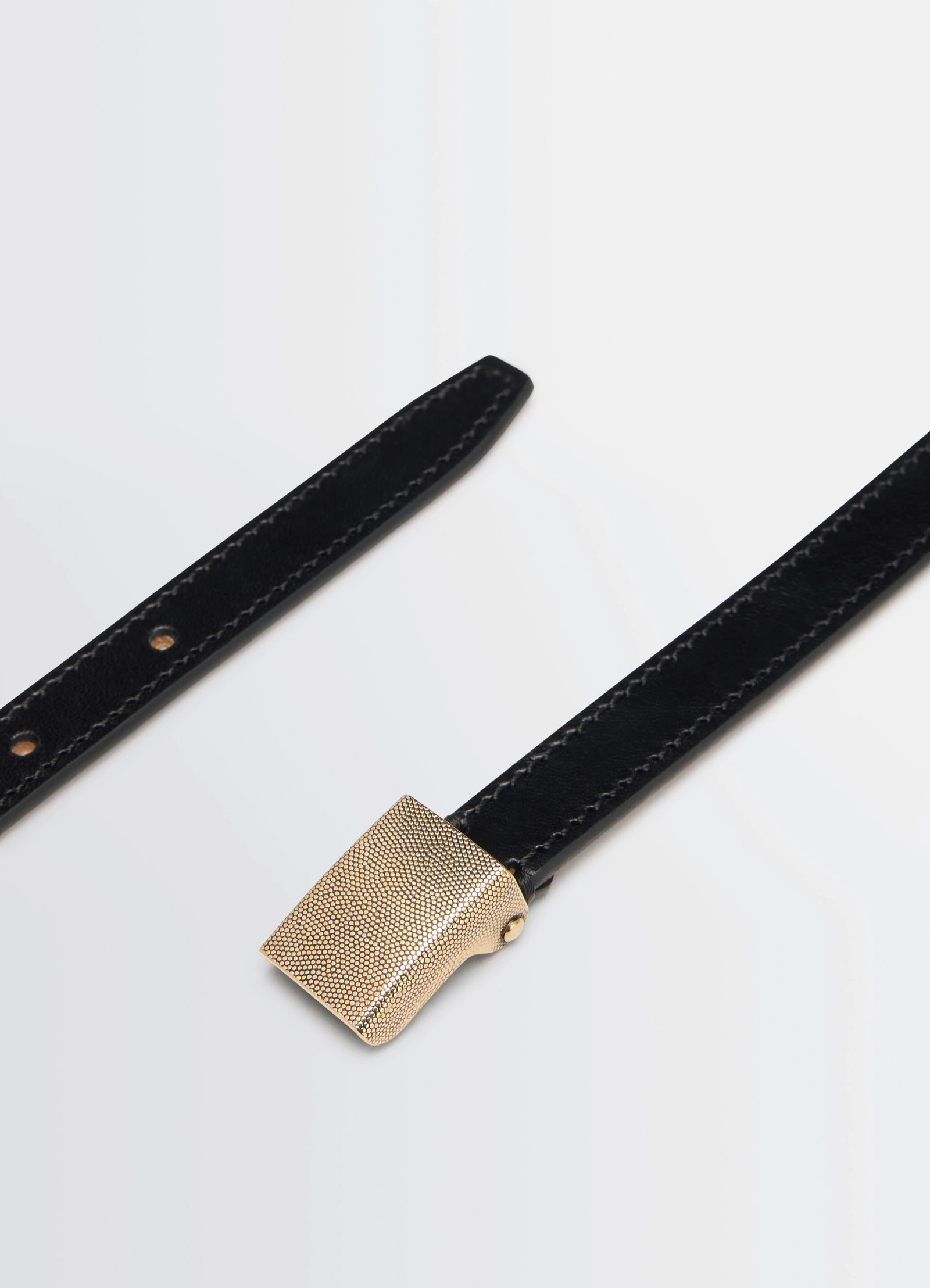 Lemaire clip belt 15mm in vegetable-tanned black leather, product shot, angled view contrasting stitching