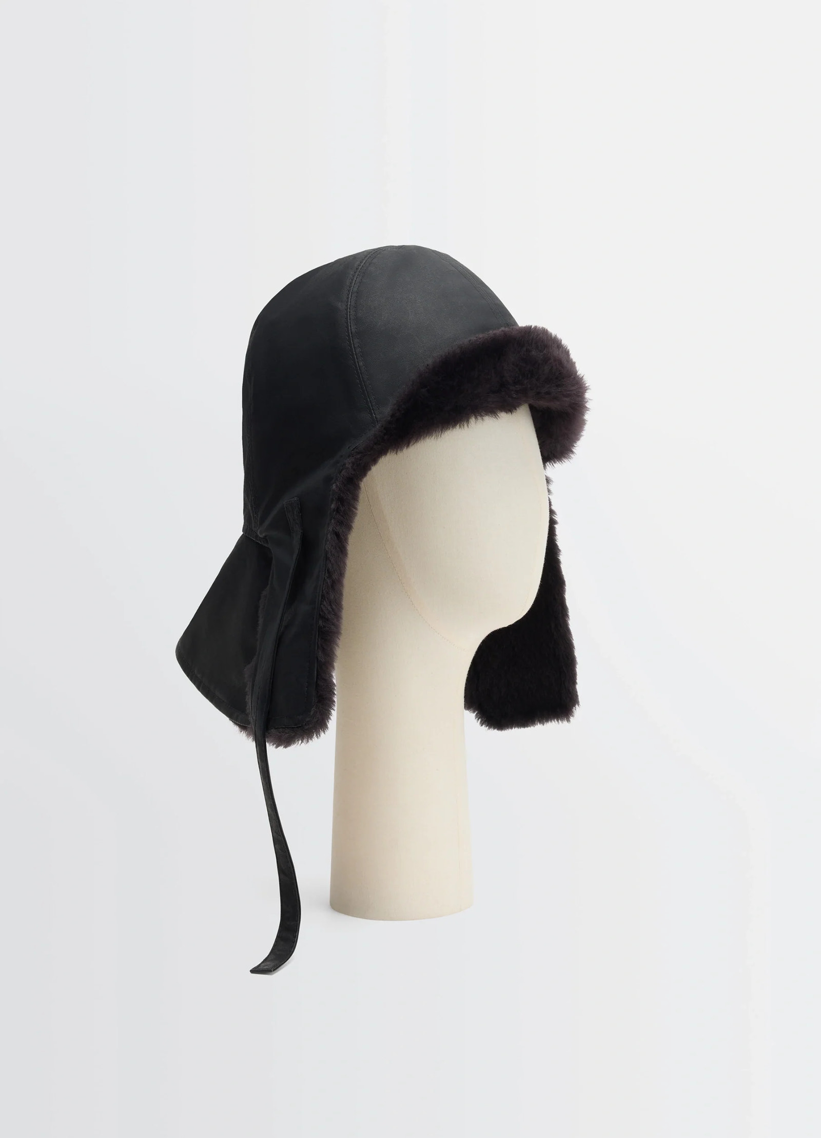 Lemaire reversible shearling chapka in black water-repellent cotton, product shot, three-quarter view extended ear flaps