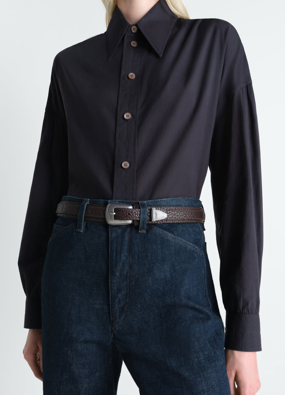 Minimal Western leather belt in brown with silver buckle worn by model LEMAIRE