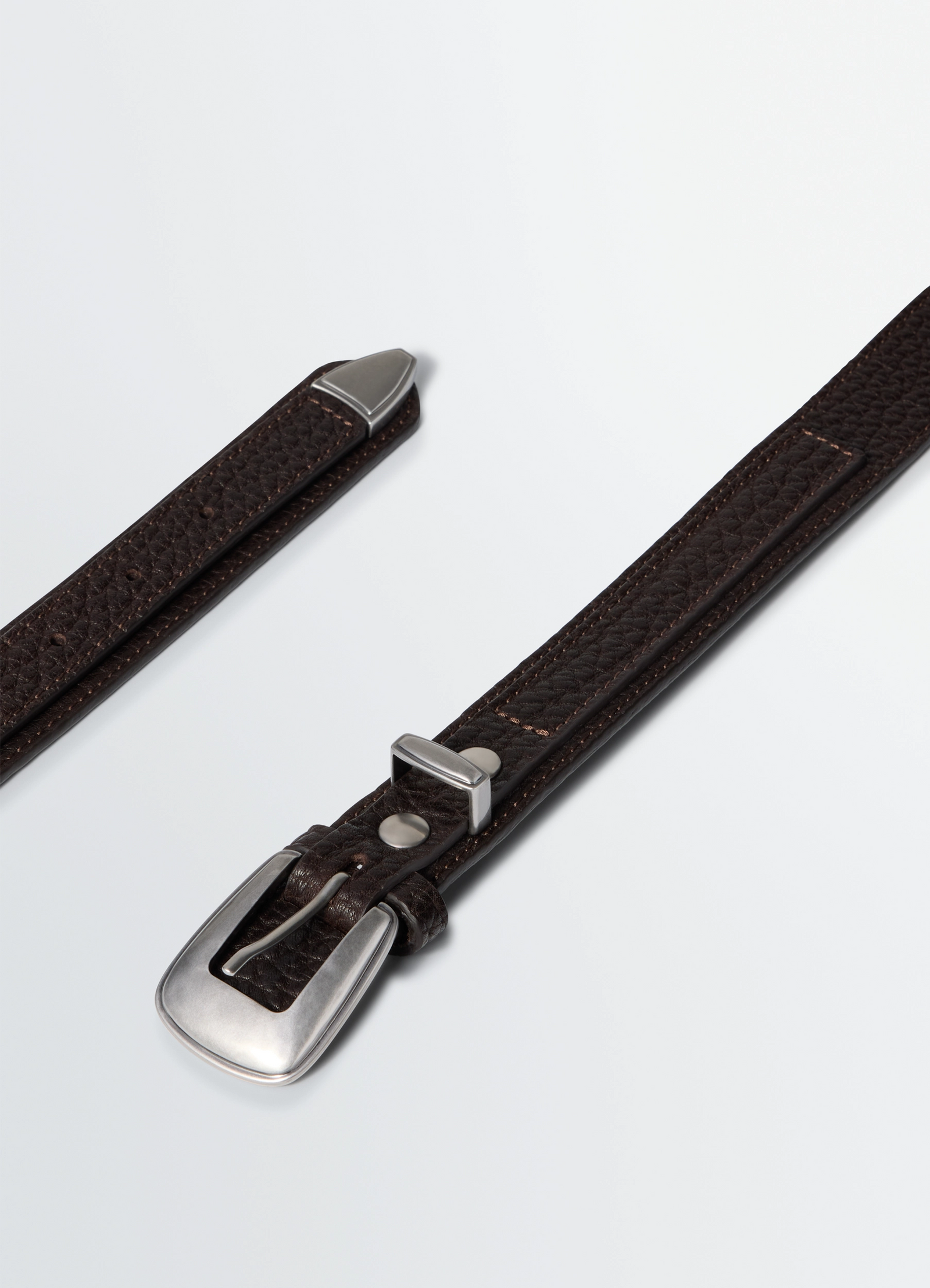 Minimal western belt in grained leather, product shot, angled top view pointed tip design