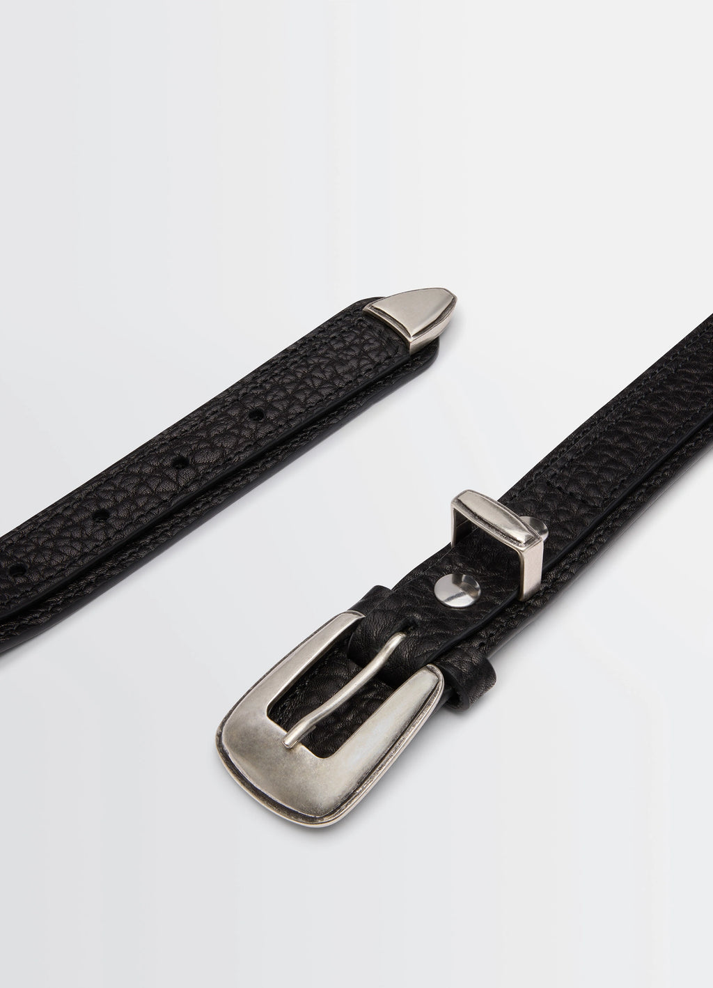 Minimal Western Belt in Grained Leather, product shot, angled detail shot silver tip accent
