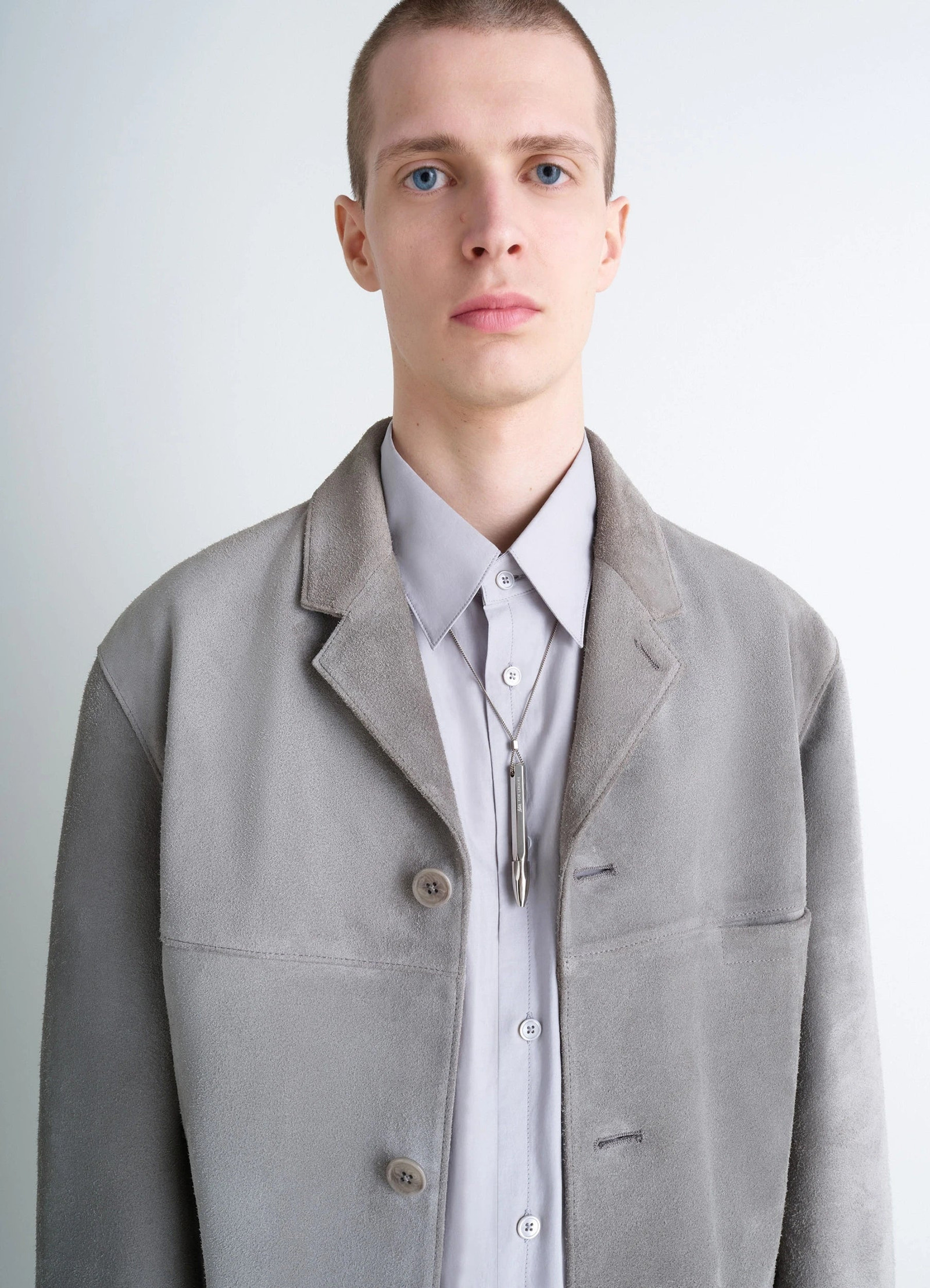 Aubock pen necklace in silver metal, model shot, front portrait view hung over buttoned shirt