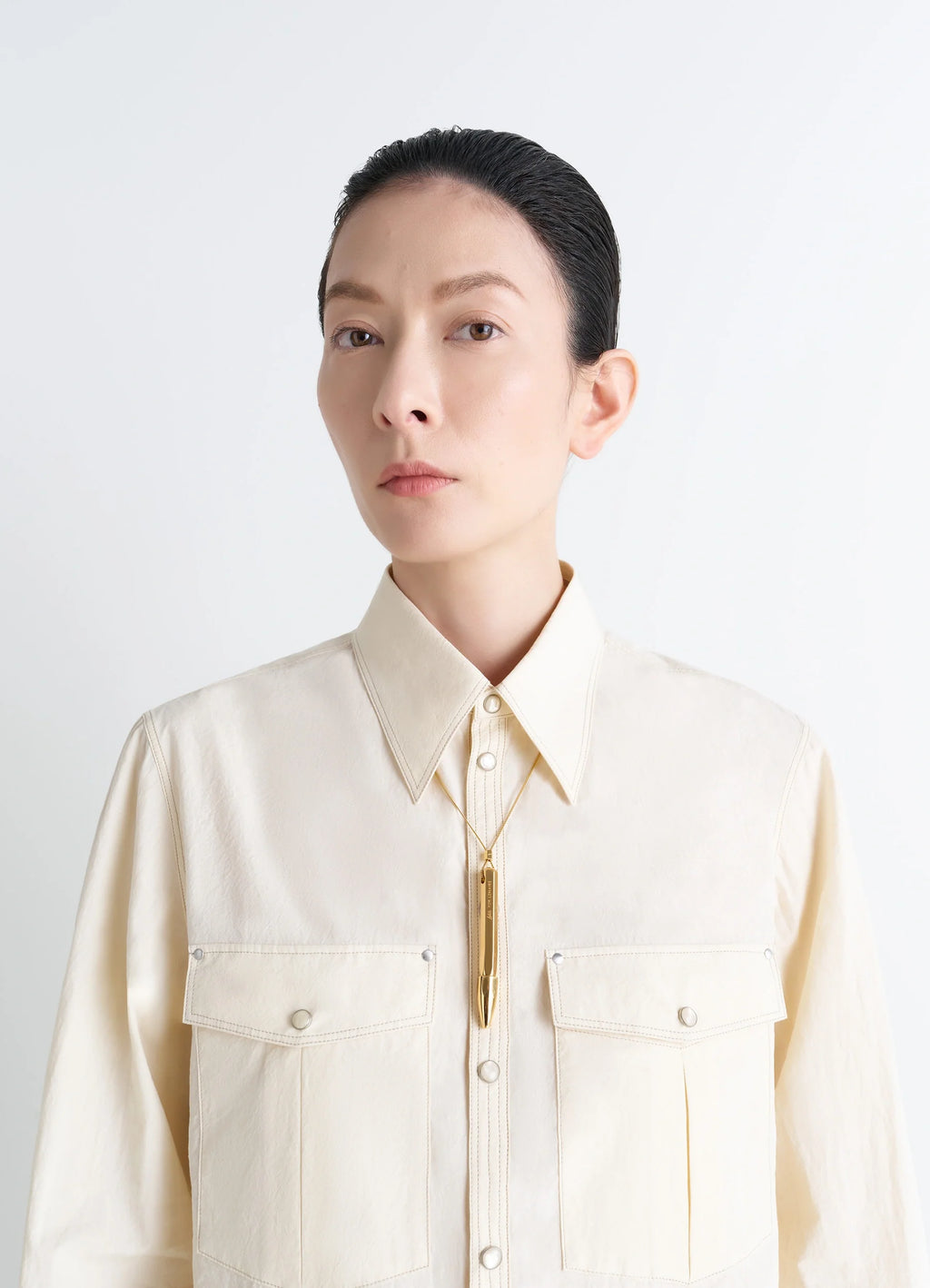 AUBOCK Pen Necklace in Gold Tone Metal, model shot, three-quarter view button-front shirt