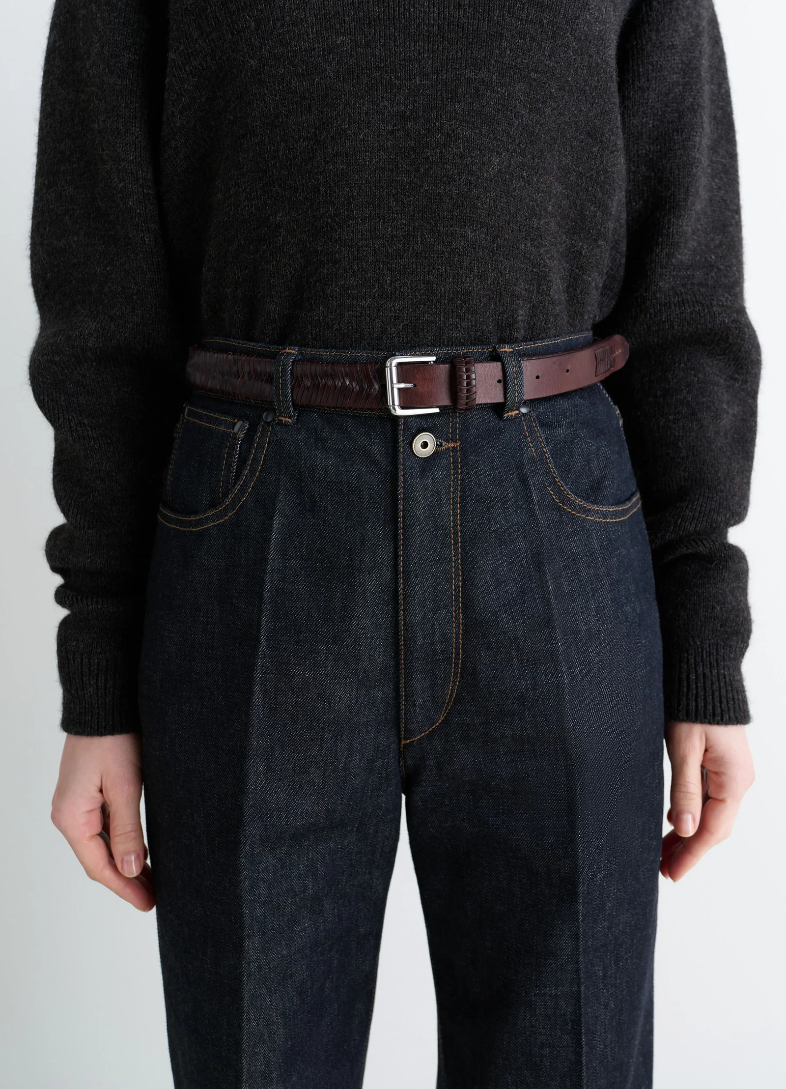 Weaved belt 25 in shiny braided leather, model shot, waist level detail silver buckle accent