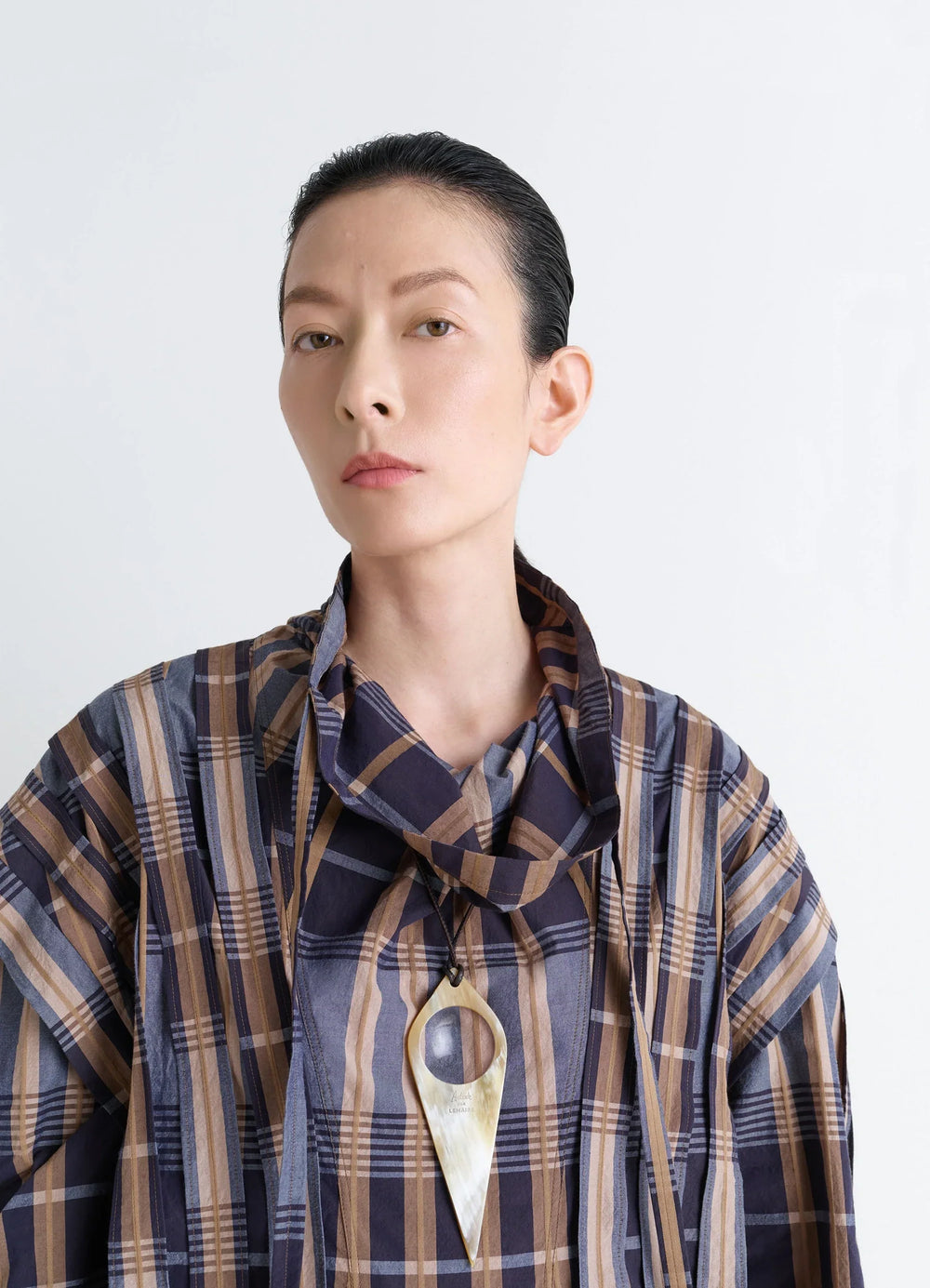 AUBOCK Magnifying Glass Necklace in Horn, model shot, portrait view worn over plaid shirt
