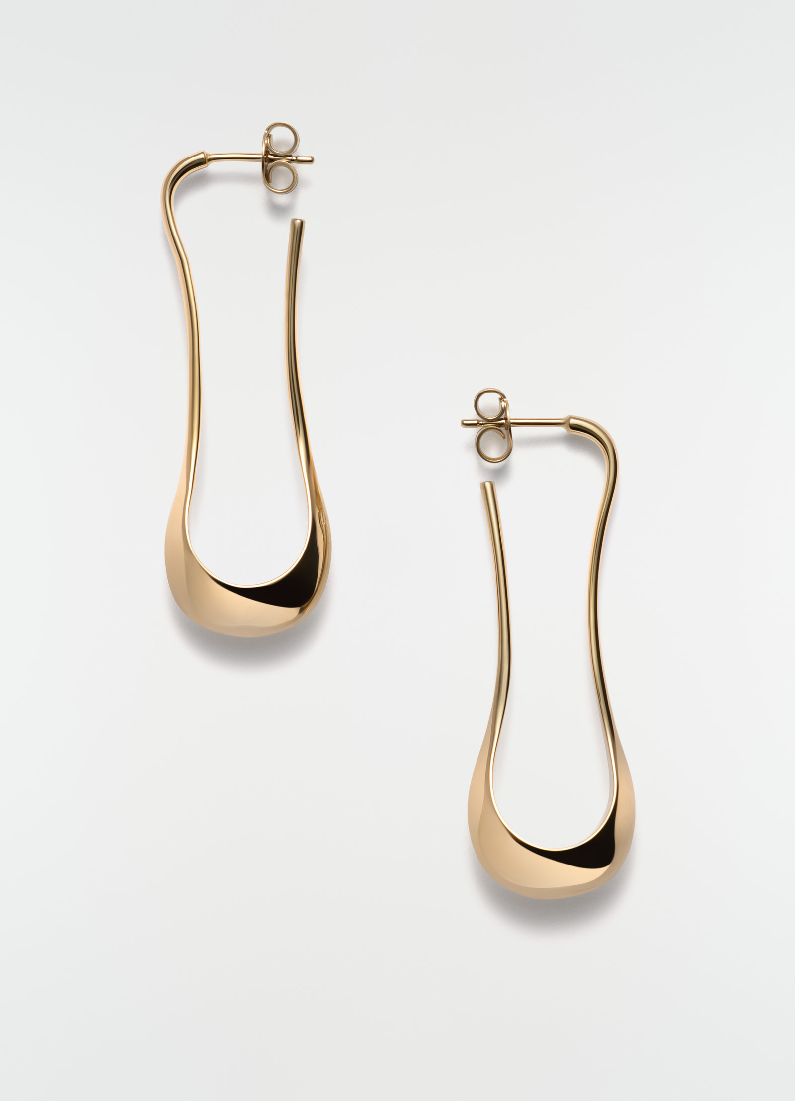 Short gold vermeil drop earrings by lemaire on plain white background with curvy u-shape design