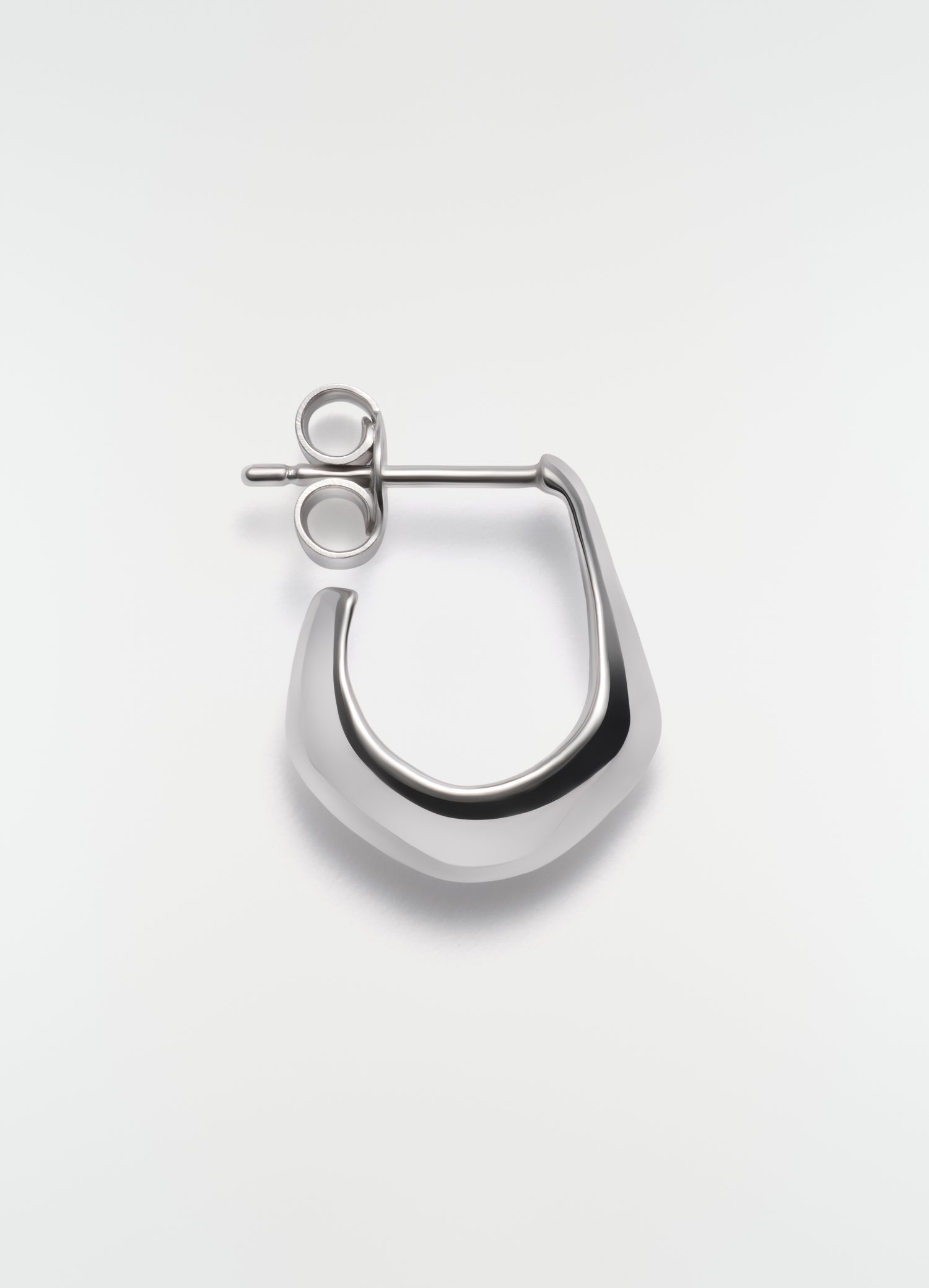 Mini silver metal drop earring by LEMAIRE on plain white background close-up detail