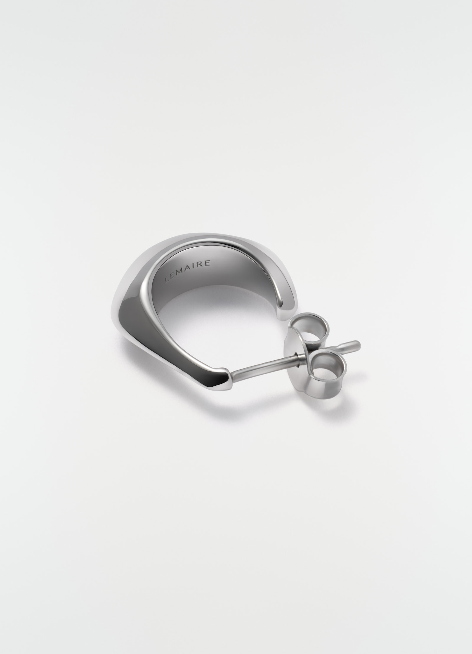 Mini drop silver earring in polished metal by lemaire close-up detail on white background