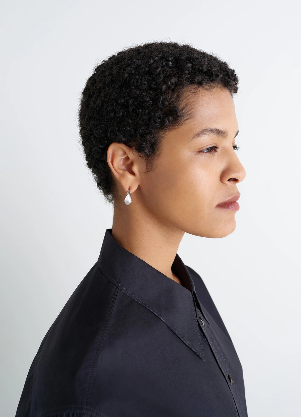 Lemaire Curved Mini Drop Earrings in Rhodium-Plated Silver, model shot, side view worn profile shot