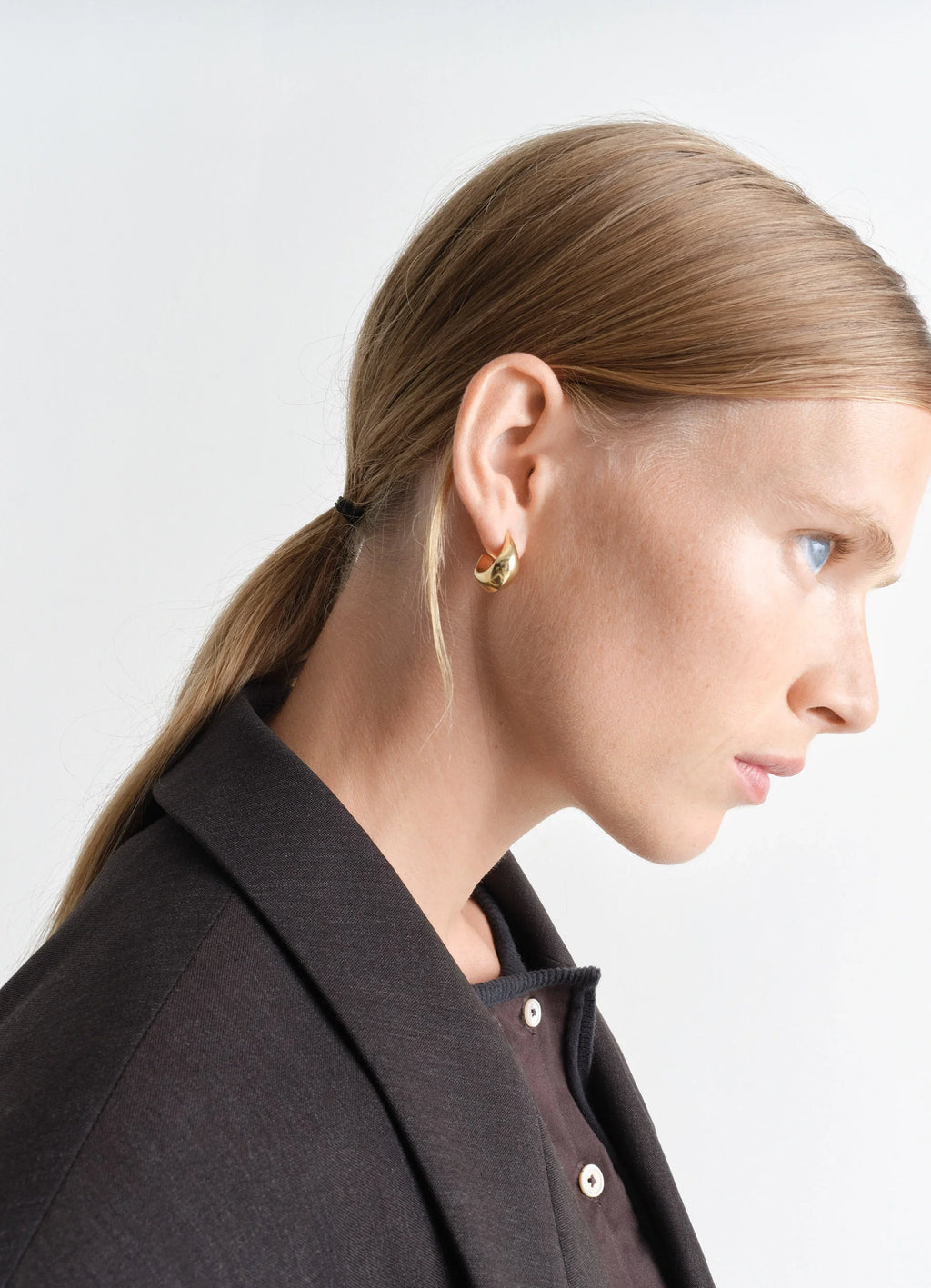 Lemaire Curved Mini Drop Earrings in Gold Vermeil, model shot, side profile view textured surface