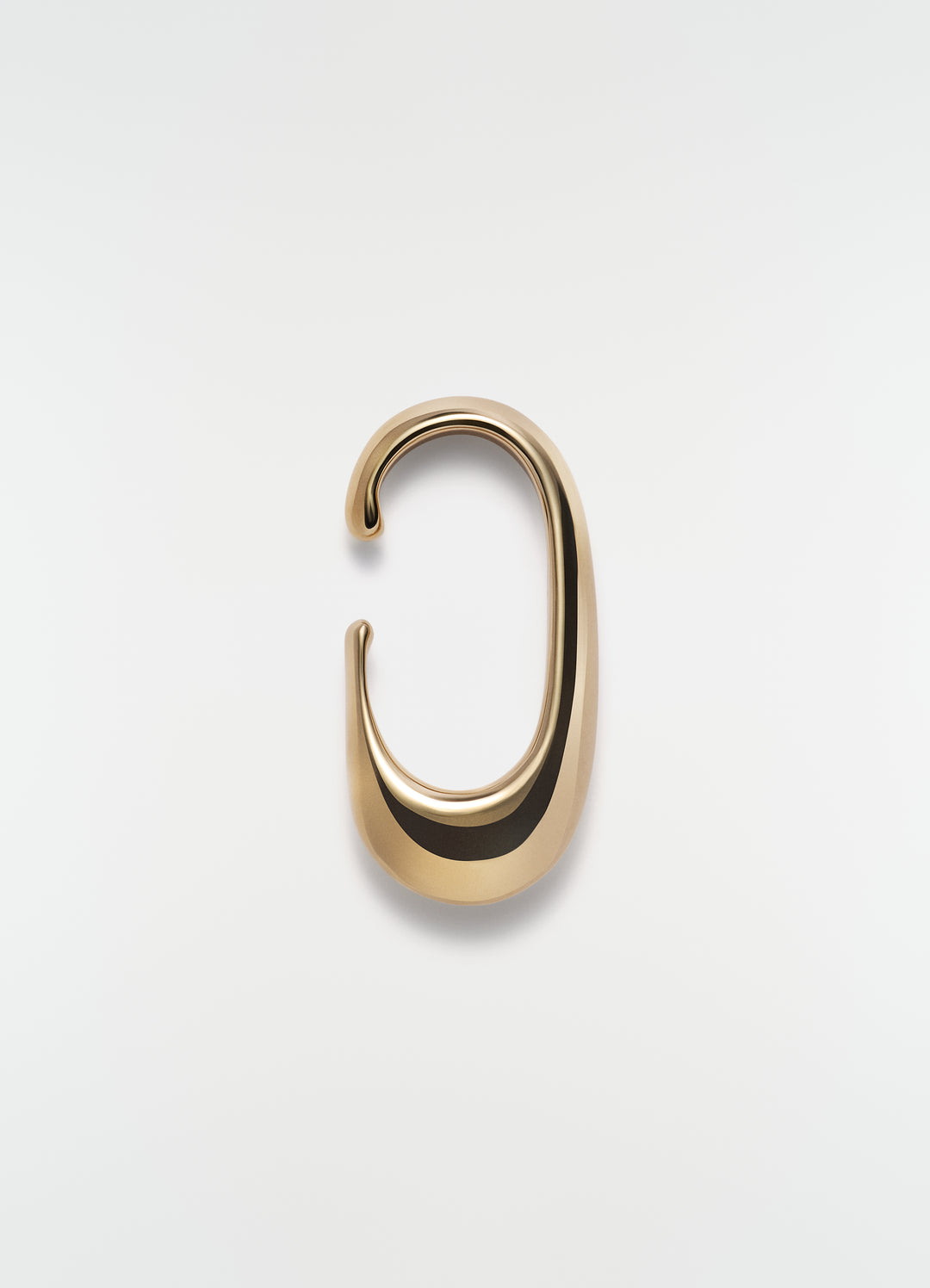 Long gold vermeil drop earcuff by LEMAIRE on plain white background close-up detail
