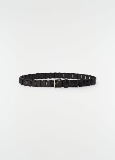 Link belt in black vegetable-tanned leather with silver buckle by LEMAIRE flat lay on white background