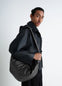 Lemaire Large Croissant Bag in Black Nappa Lamb Leather, model shot, Side view Smooth hand curve design