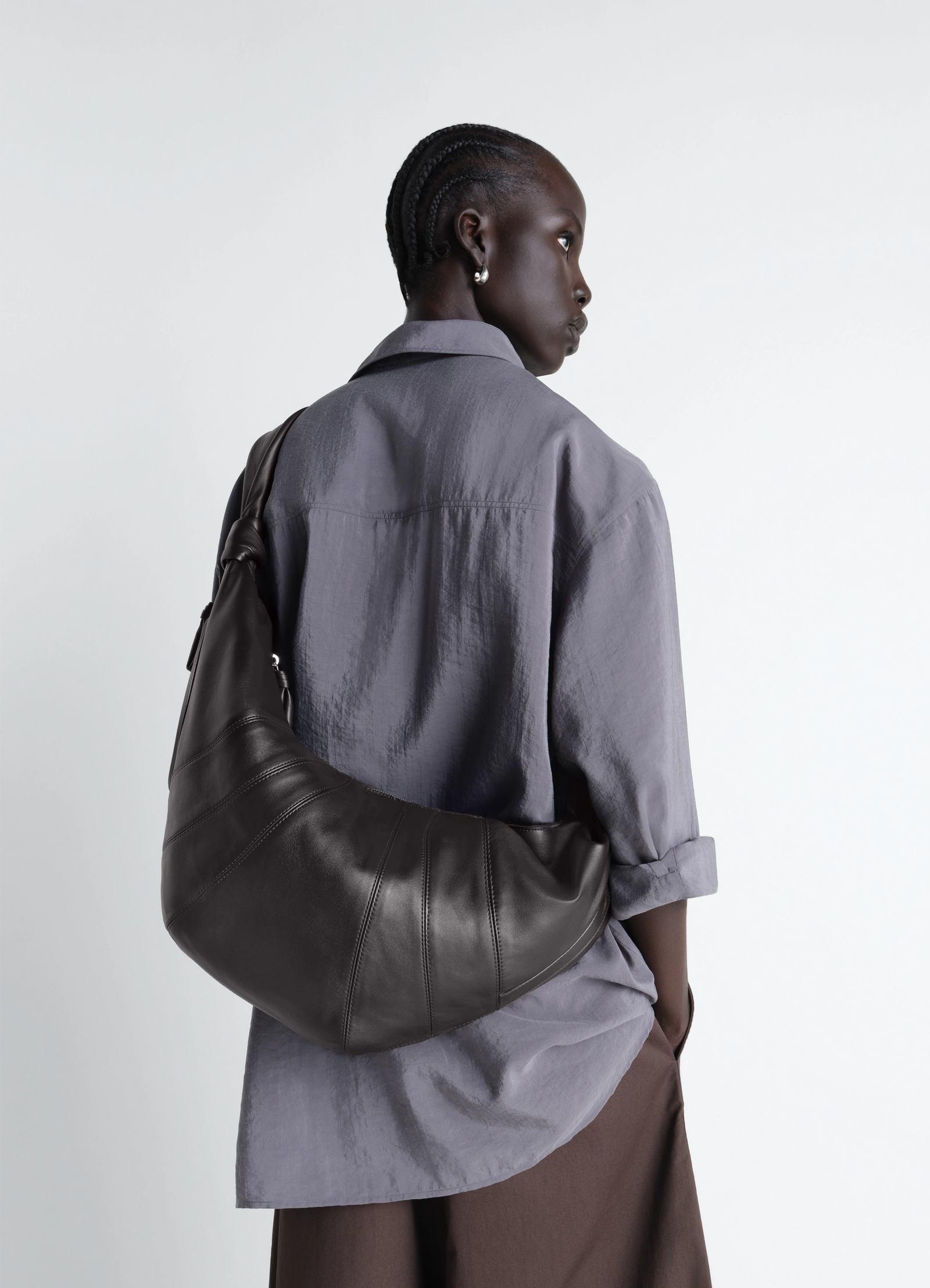 Lemaire large croissant bag in nappa lamb leather, model shot, over-the-shoulder view soft curved silhouette