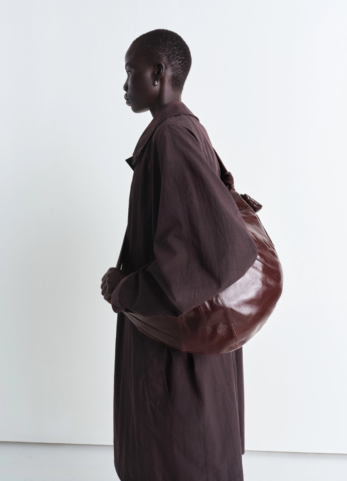 Lemaire Large Croissant Bag in coated cotton canvas, model shot, side view textured shiny look
