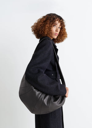 Lemaire Large Croissant Bag in Grained Leather, model shot, Side view Knotted elements visible