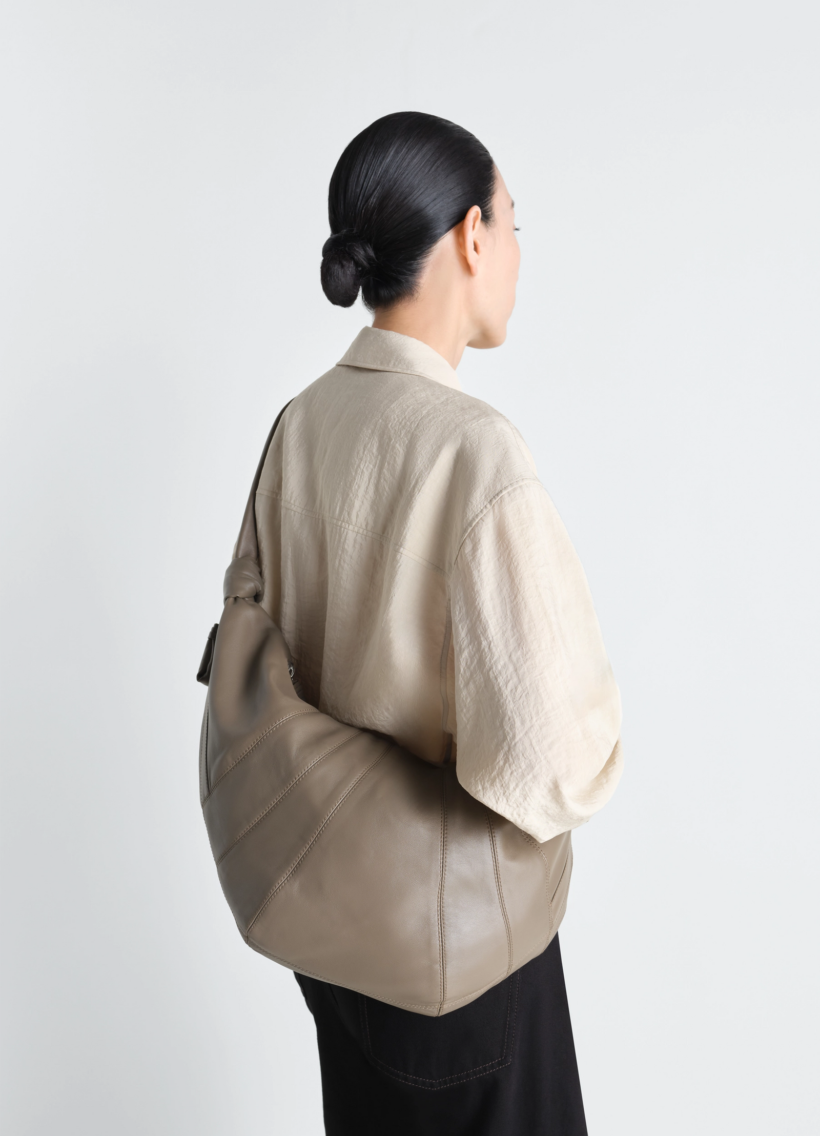 Lemaire large croissant bag in nappa lamb leather, model shot, back view curved silhouette