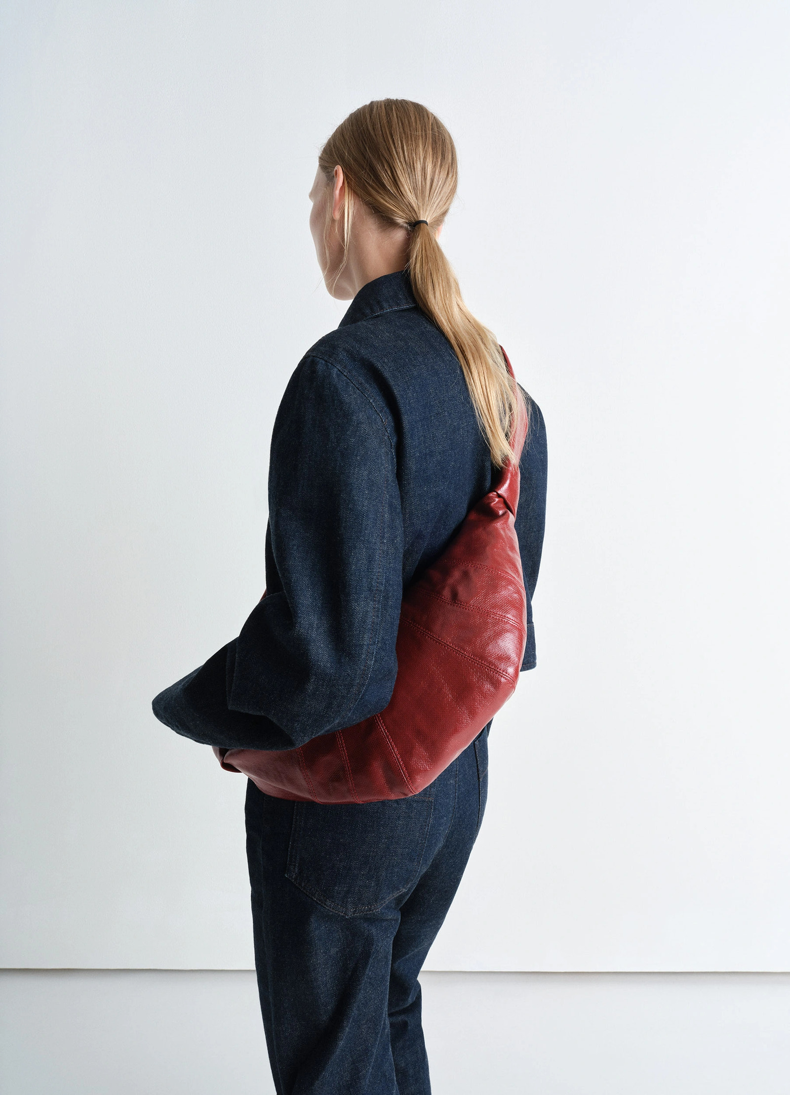 Lemaire medium croissant bag in coated cotton canvas, model shot, back view slouchy fit design