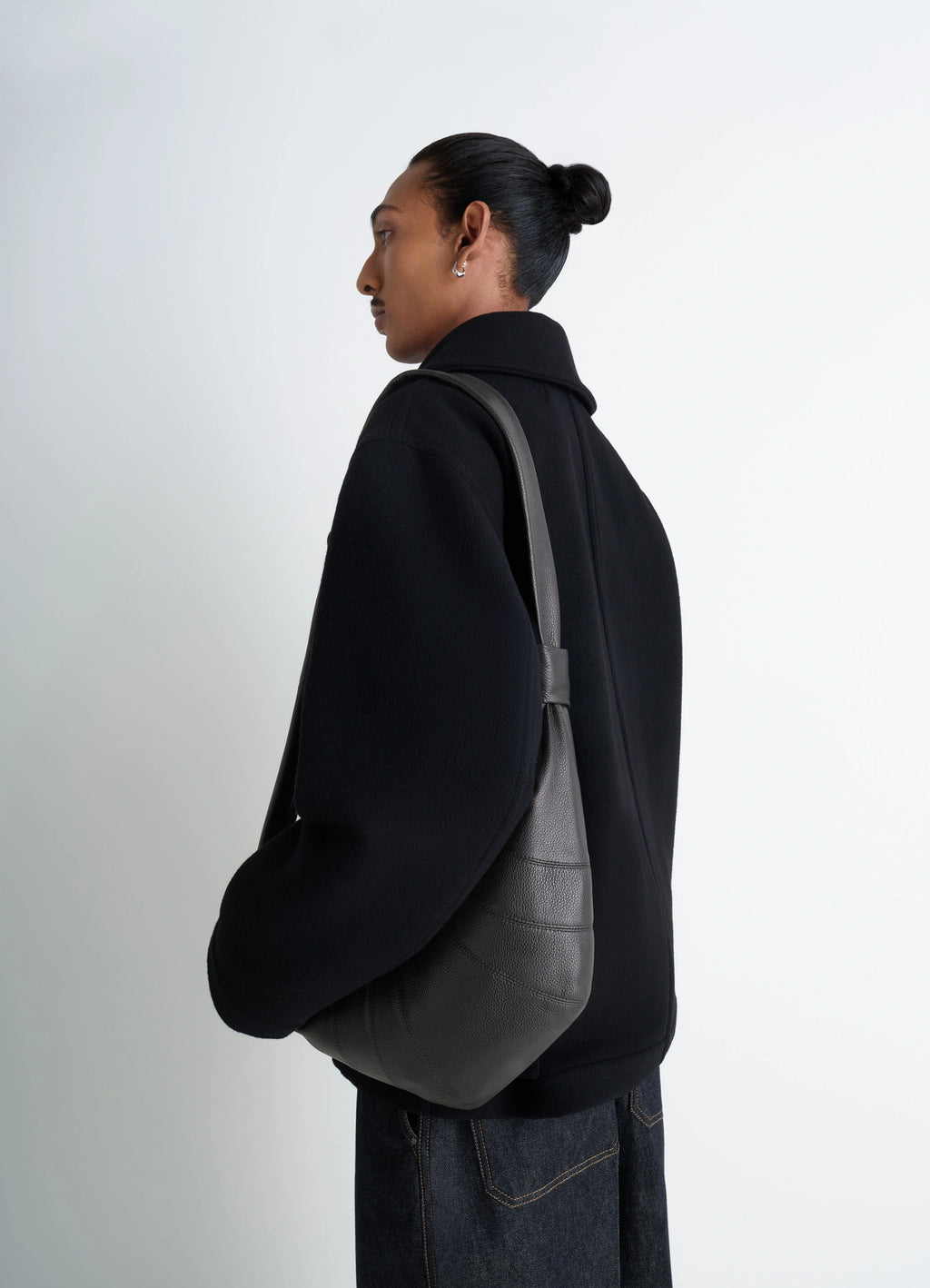 Lemaire Medium Croissant Bag in Grained Leather, model shot, over-the-shoulder view sleek strap design
