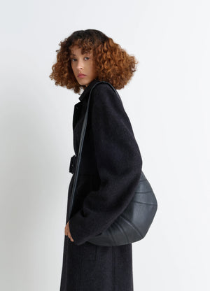 Lemaire Medium Croissant Bag in Grained Leather, model shot, Side view Curved silhouette