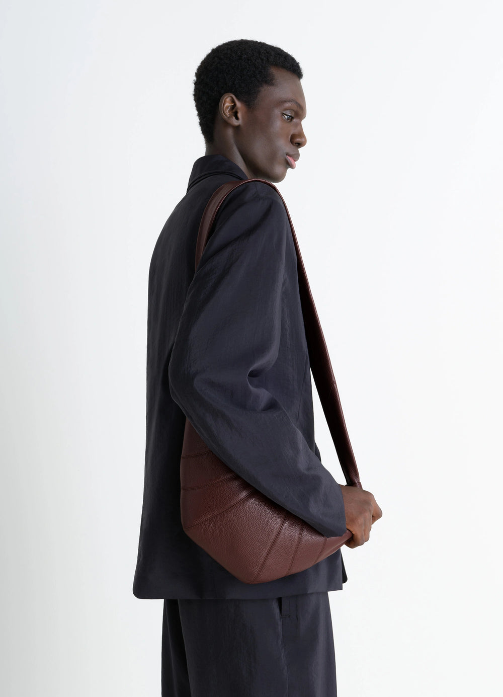 Lemaire Medium Croissant Bag in Grained Leather, model shot, Side View Curved Topstitched Panels