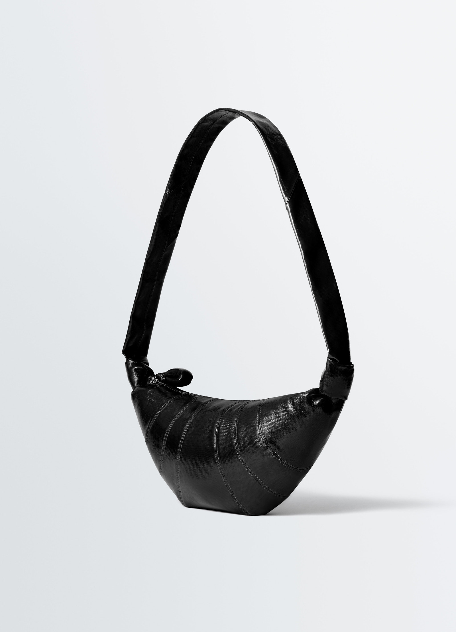 Medium black leather croissant bag with wide strap and knot detail lemaire on plain white background