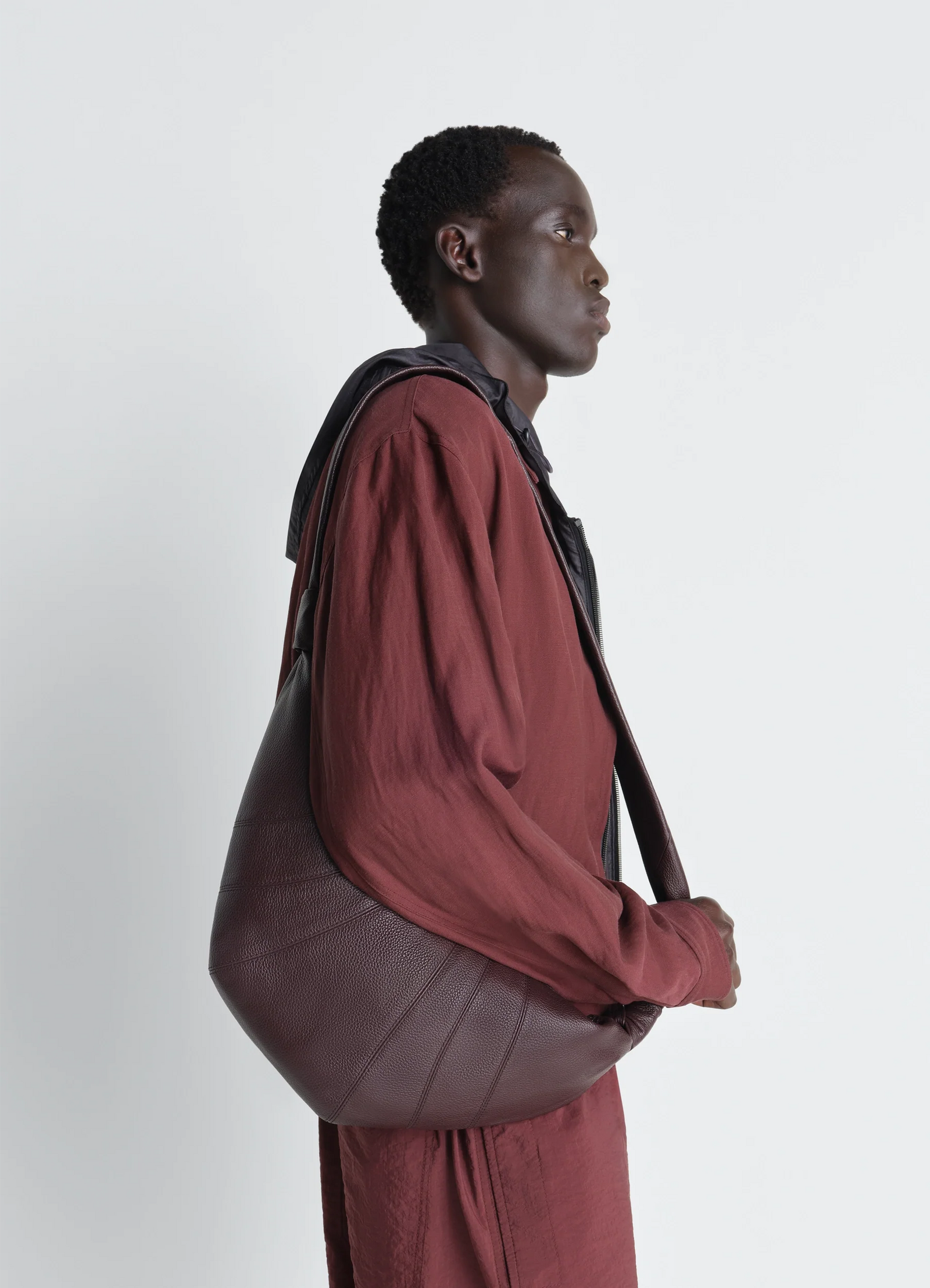 Medium croissant bag in grained leather, model shot, back view curved silhouette