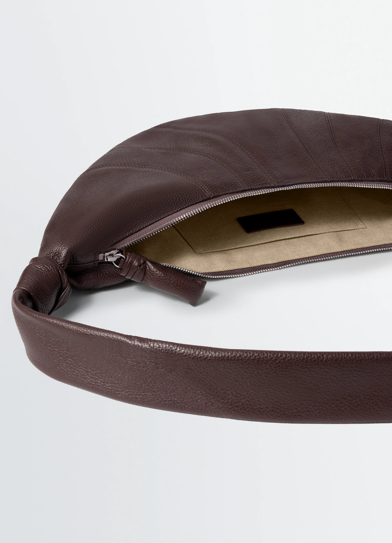 Medium croissant bag in grained leather, product shot, interior view zippered closure visible