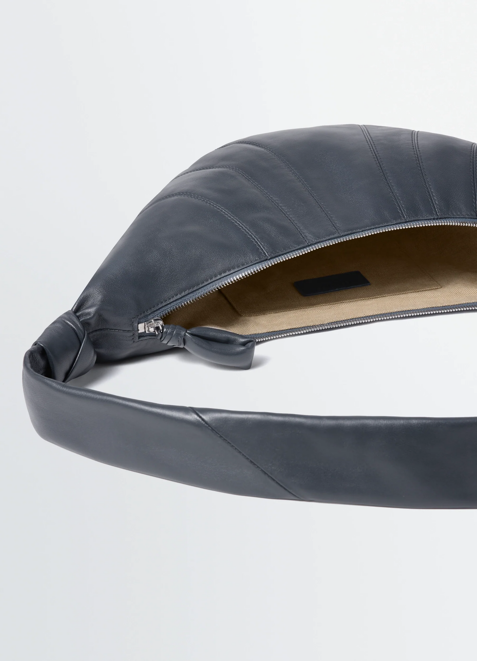 Medium croissant bag in leather, product shot, open zipper top view soft nappa texture