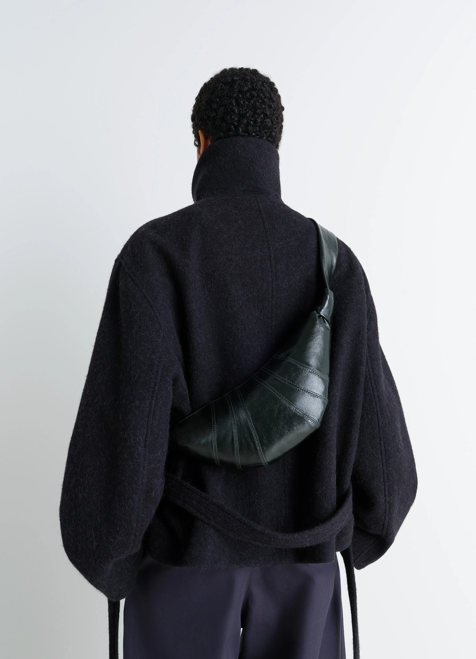 Lemaire small croissant bag in coated cotton canvas, model shot, rear diagonal view crossbody wear detail