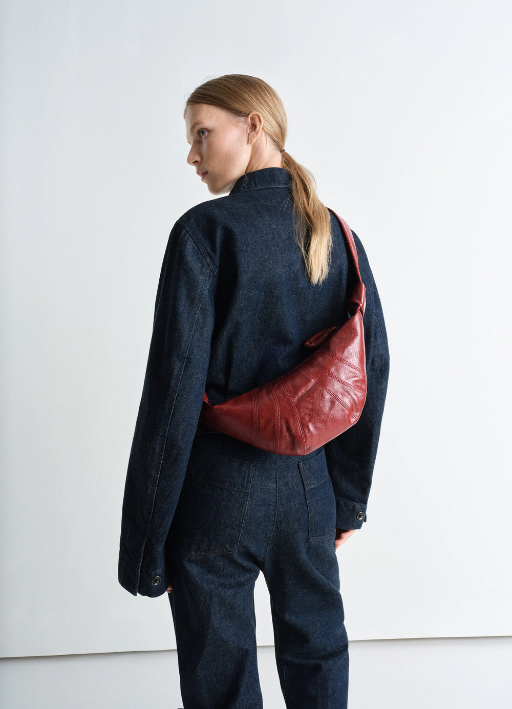 Lemaire Small Croissant Bag in Coated Cotton Canvas, model shot, over-the-shoulder view slouchy fit with red tone