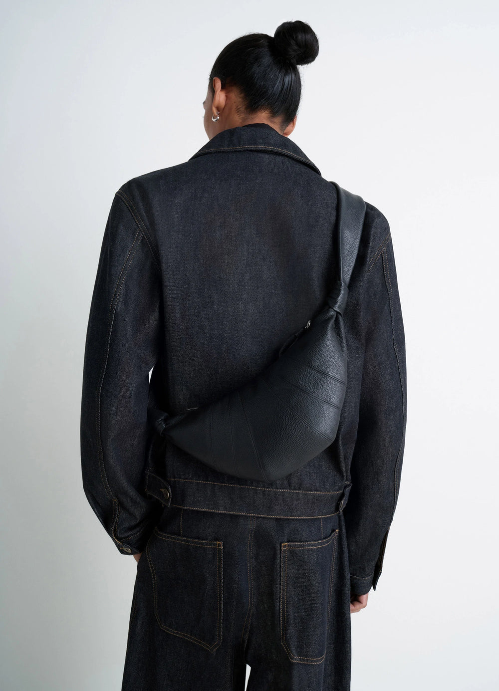 Small Croissant Bag in Black Grained Leather, model shot, over-the-shoulder view worn crossbody style