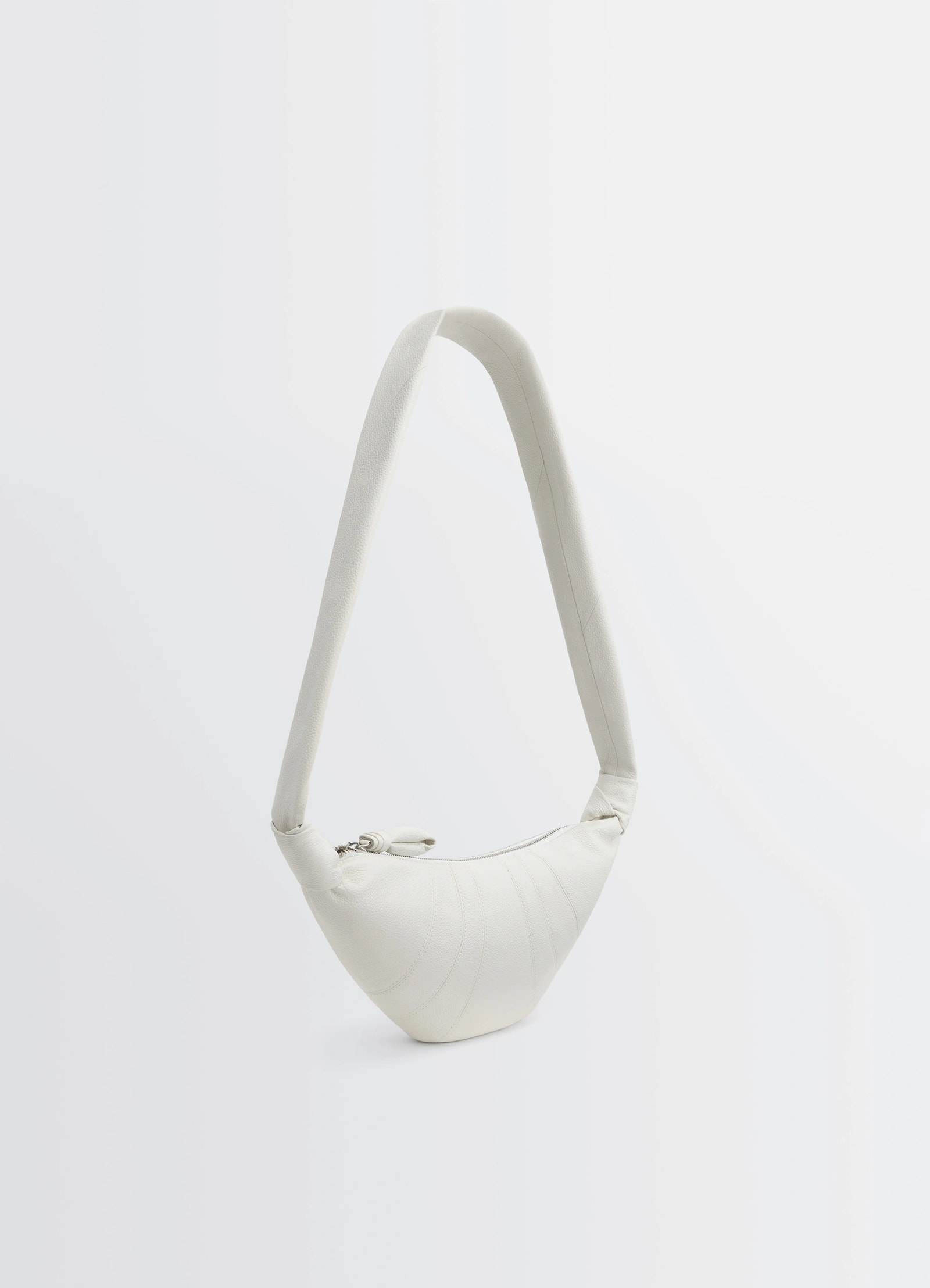Lemaire small croissant bag in soft grained leather, product shot, angled hanging view elevated strap position