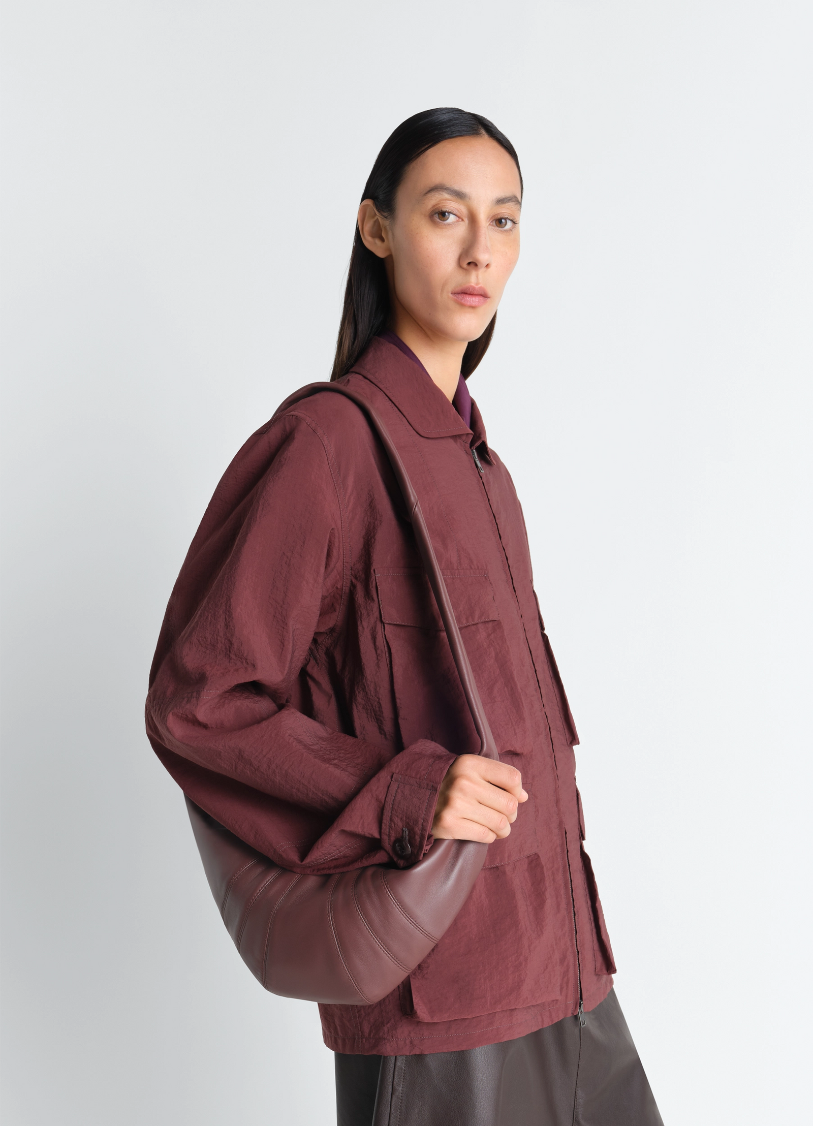 Small croissant bag in leather nappa lambskin, model shot, side view curved silhouette