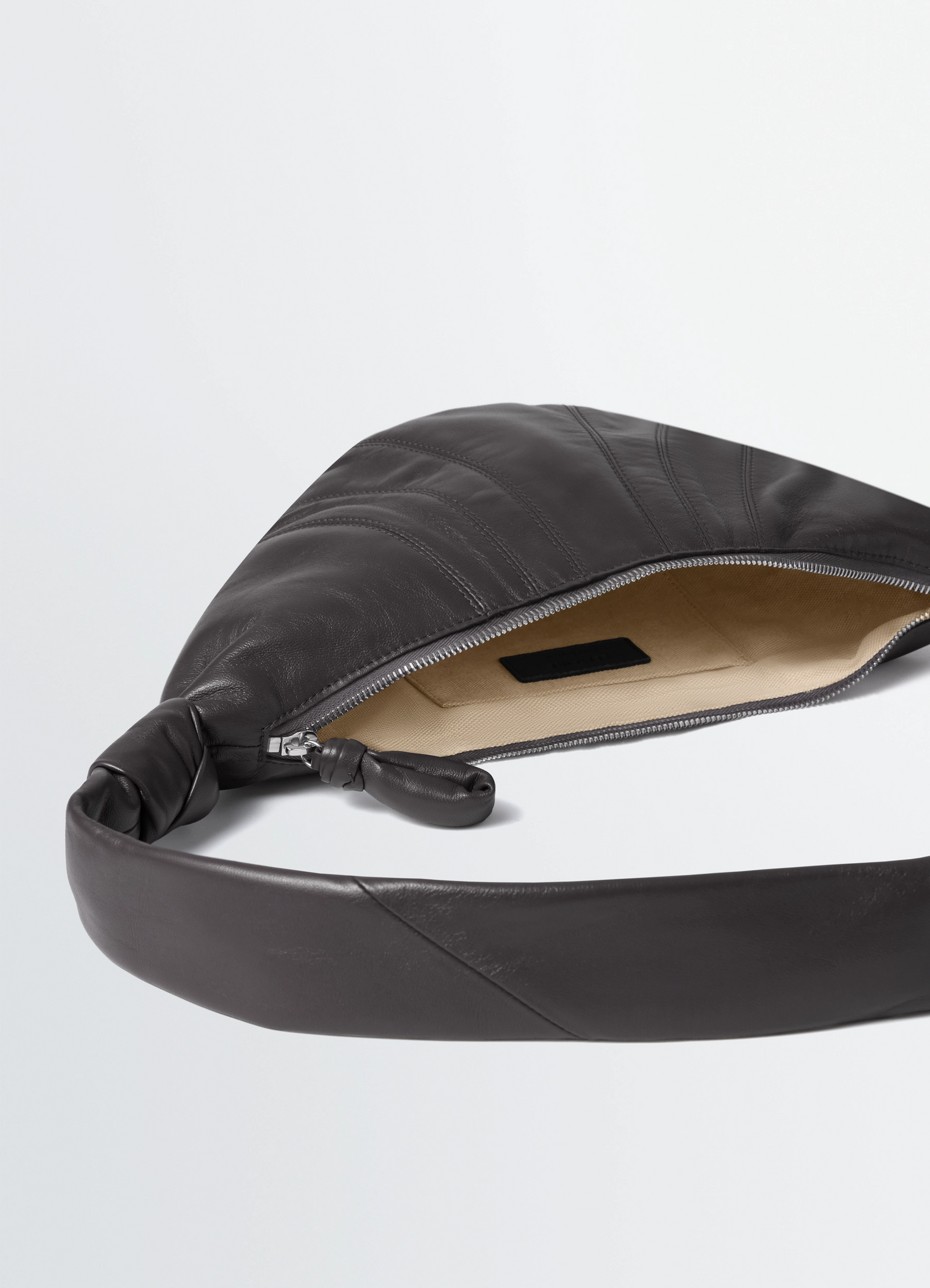 Small croissant bag in nappa lamb leather, product shot, zipper detail shot interior and opening view