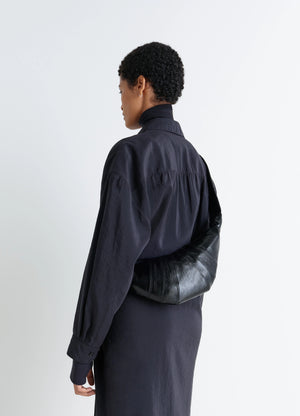 Lemaire Small Croissant Bag in Black Coated Cotton, model shot, Side view Shoulder worn