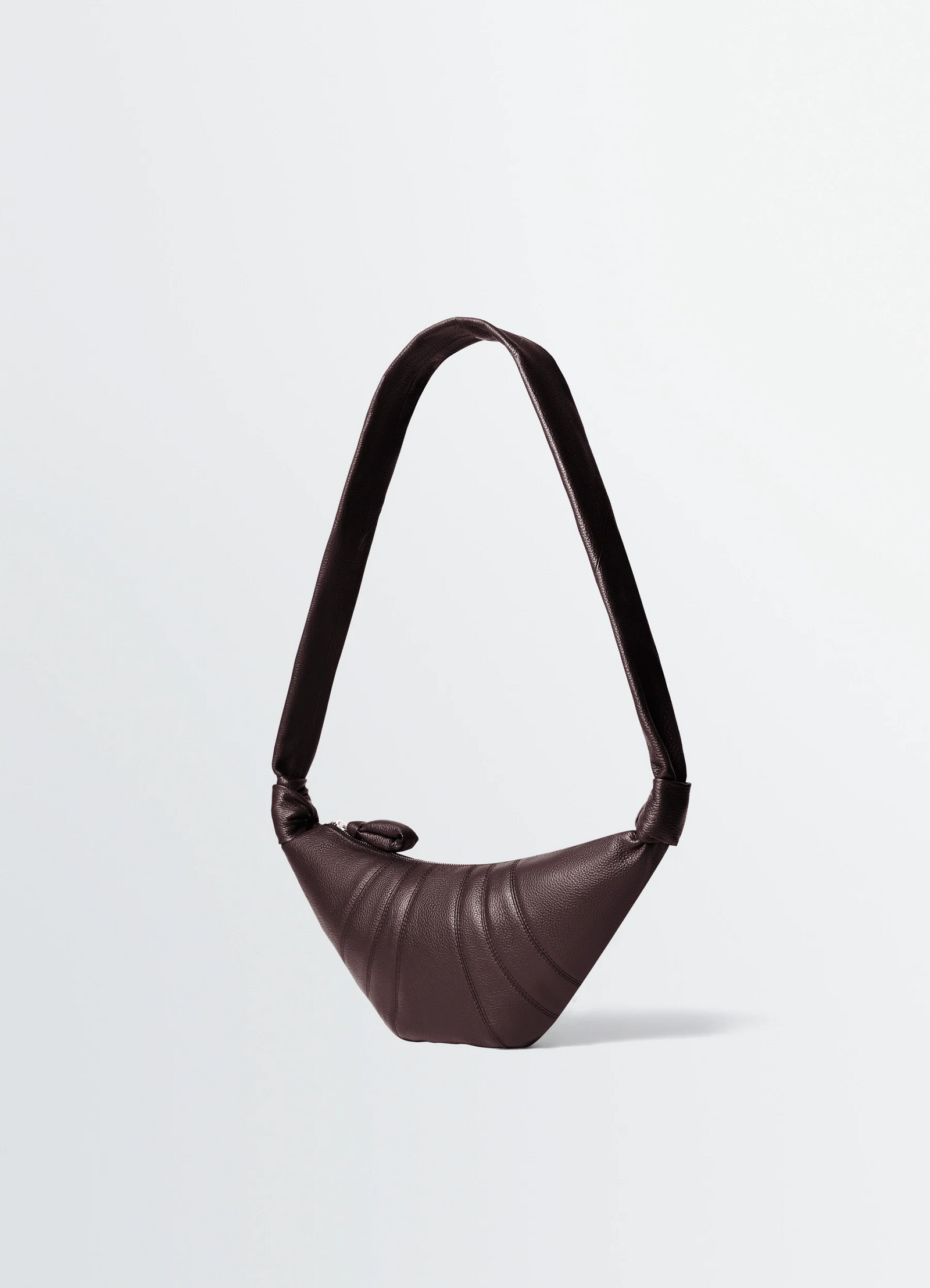 Small croissant bag in grained leather, product shot, side view knotted strap detail