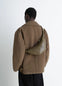 Lemaire Small Croissant Bag in Khaki Nappa Lamb Leather, model shot, back view worn over shoulder