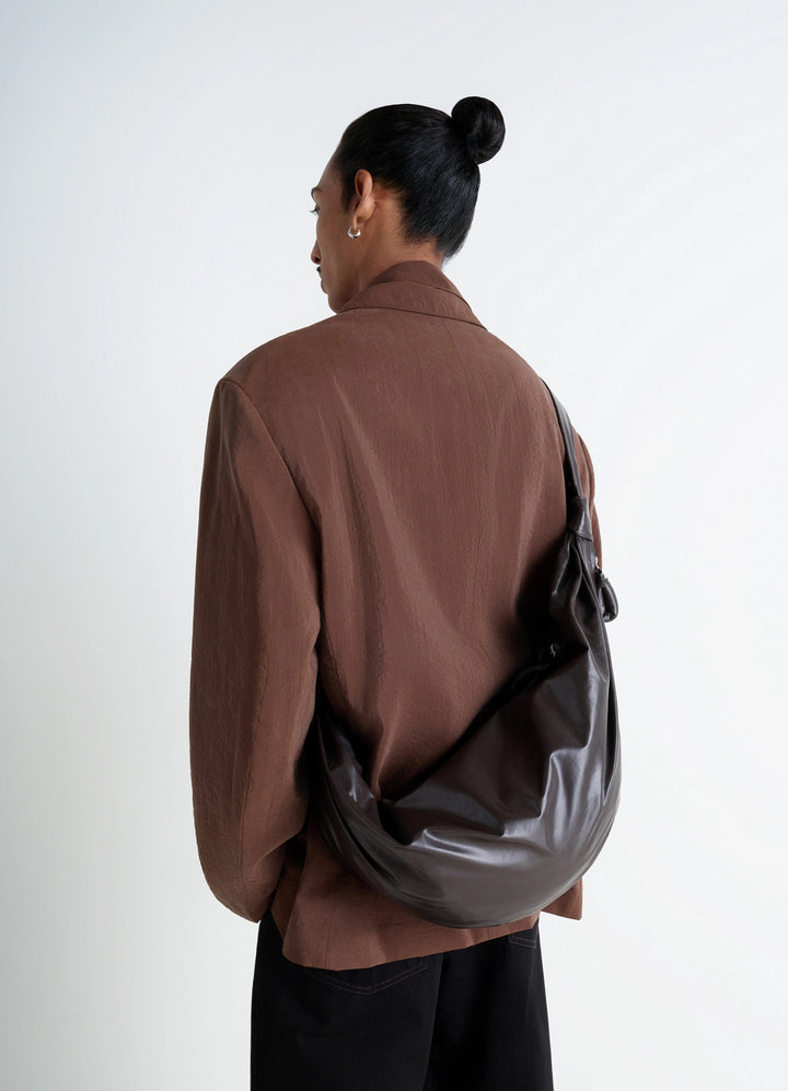 Lemaire Large Soft Croissant Bag in Paper-effect leather, model shot, Back view Curved design with pleats