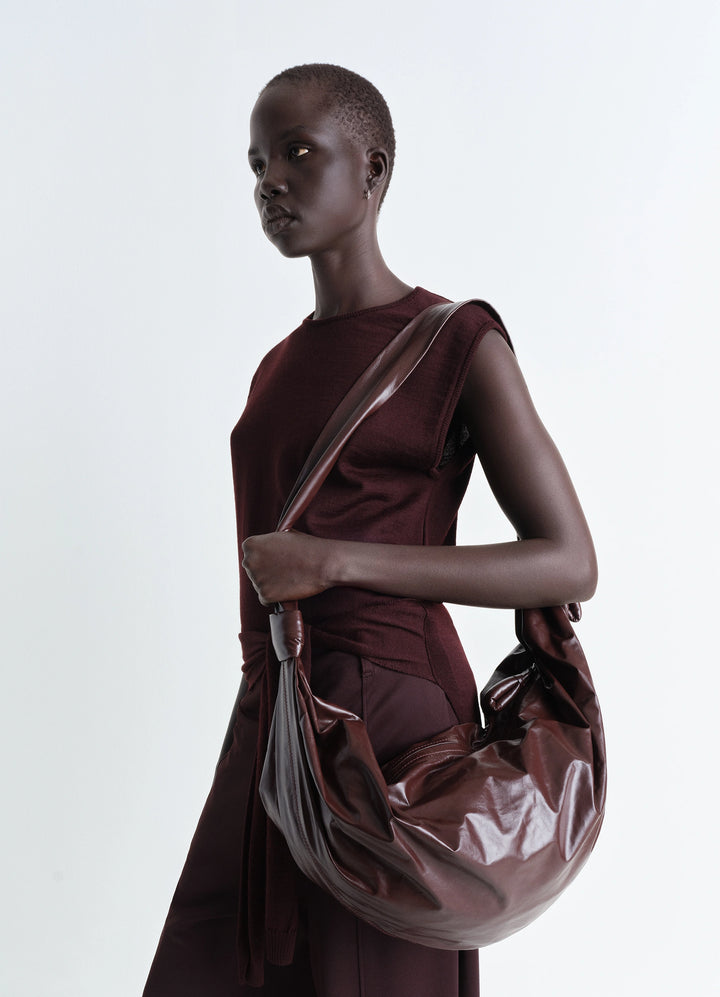Lemaire Large Soft Croissant in Paper-effect leather, model shot, Side view Knotted elements, shiny finish