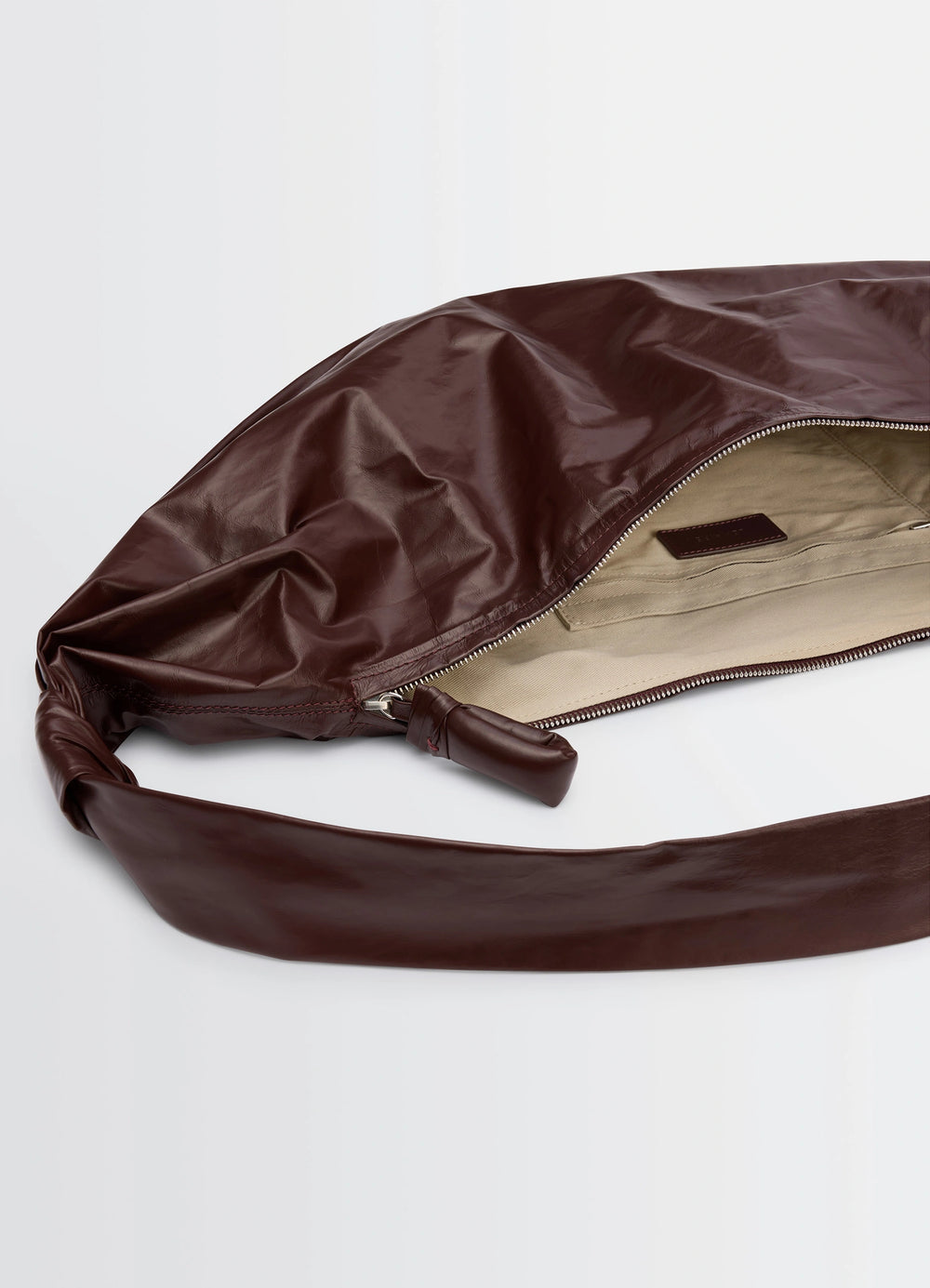 Lemaire Large Soft Croissant in Paper-effect leather, product shot, interior detail shot zippered interior compartment