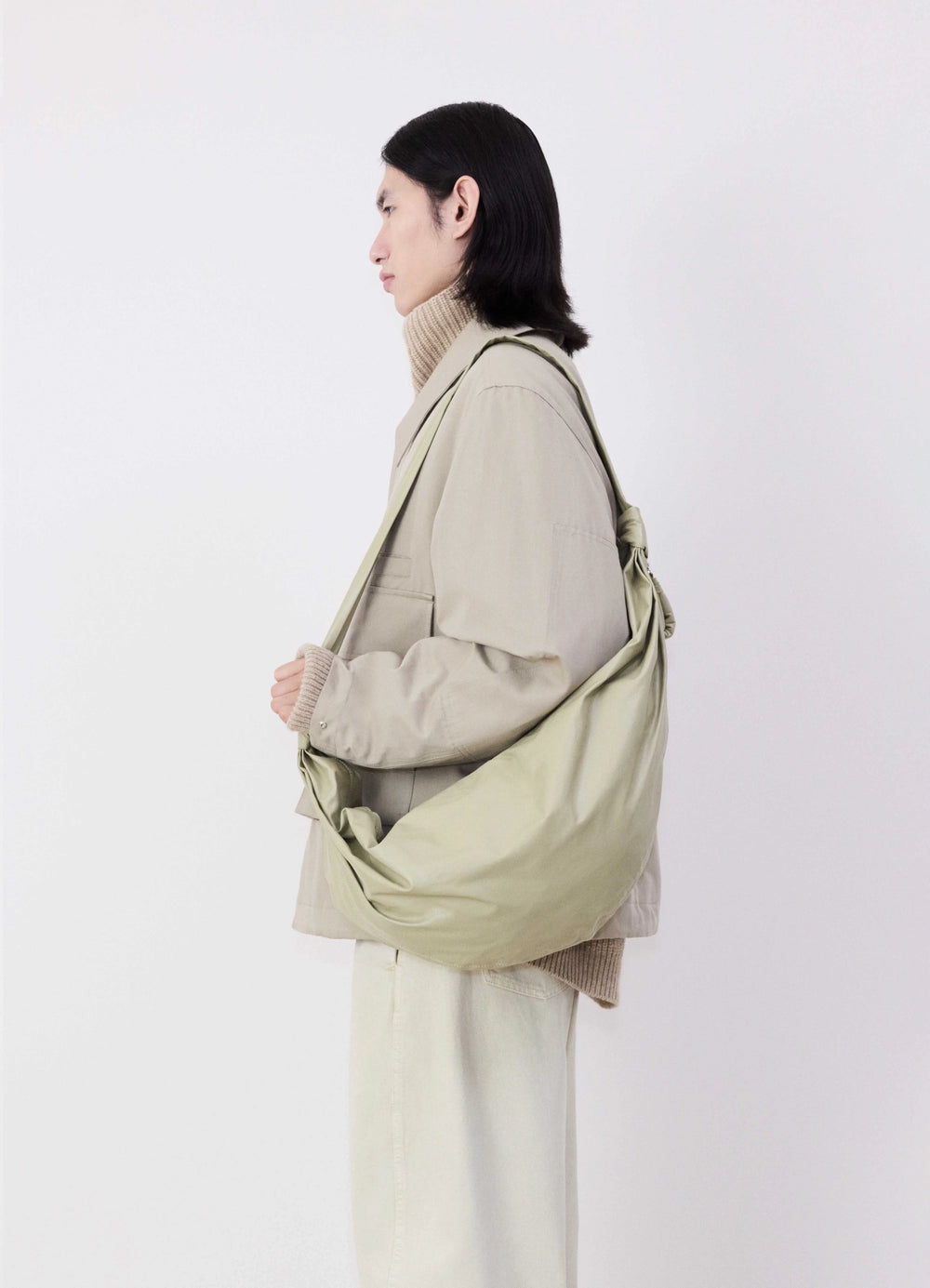 Medium Soft Croissant Bag in Lightweight Shiny Leather, model shot, worn side view slouched shoulder style