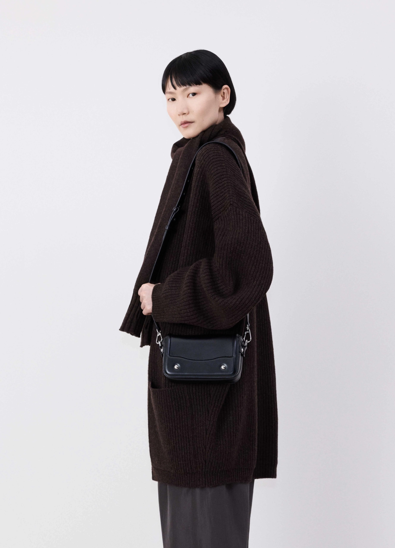 Lemaire ransel mini satchel in glossy black vegetable-tanned leath, model shot, over-the-shoulder view worn crossbody with ch