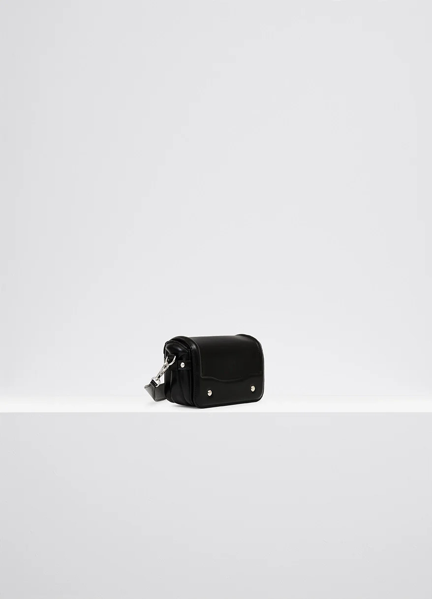 Lemaire ransel mini satchel in glossy black vegetable-tanned leath, product shot, three-quarter view compact side flap, metal