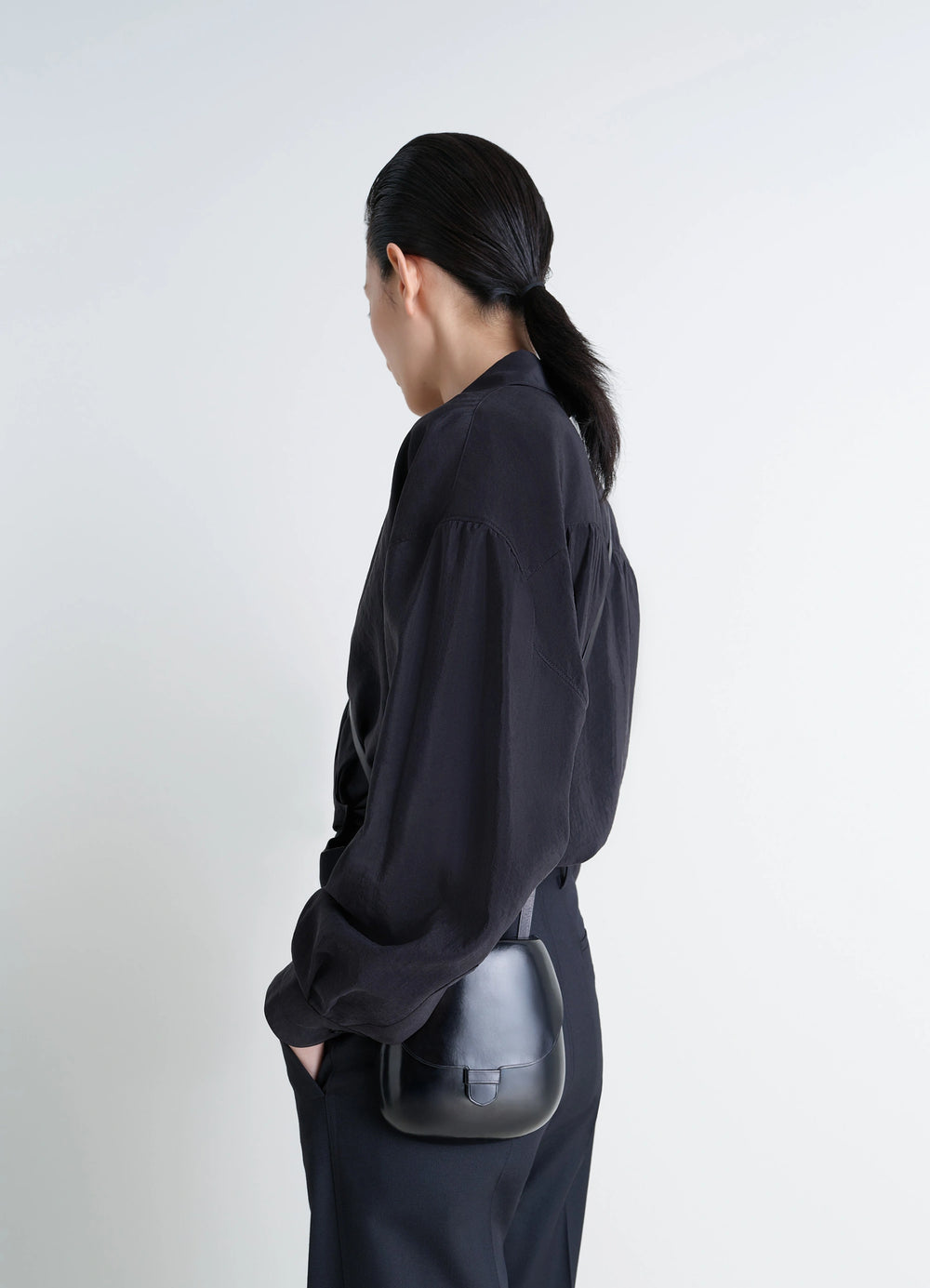 Il Bussetto for Lemaire Small Cartr in Patinated Vegetable-Tanned Leather, model shot, Back side view Worn crossbody